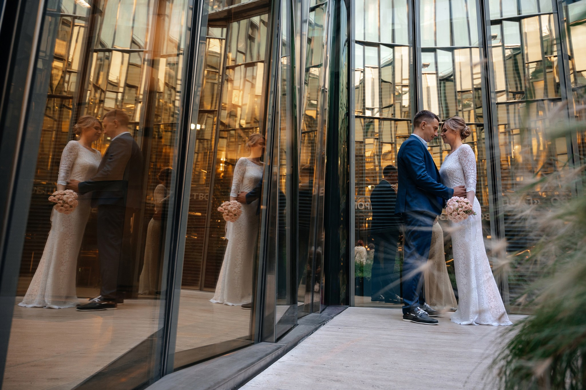 Пара фотографируется в зеркальном дворике на свадьбе