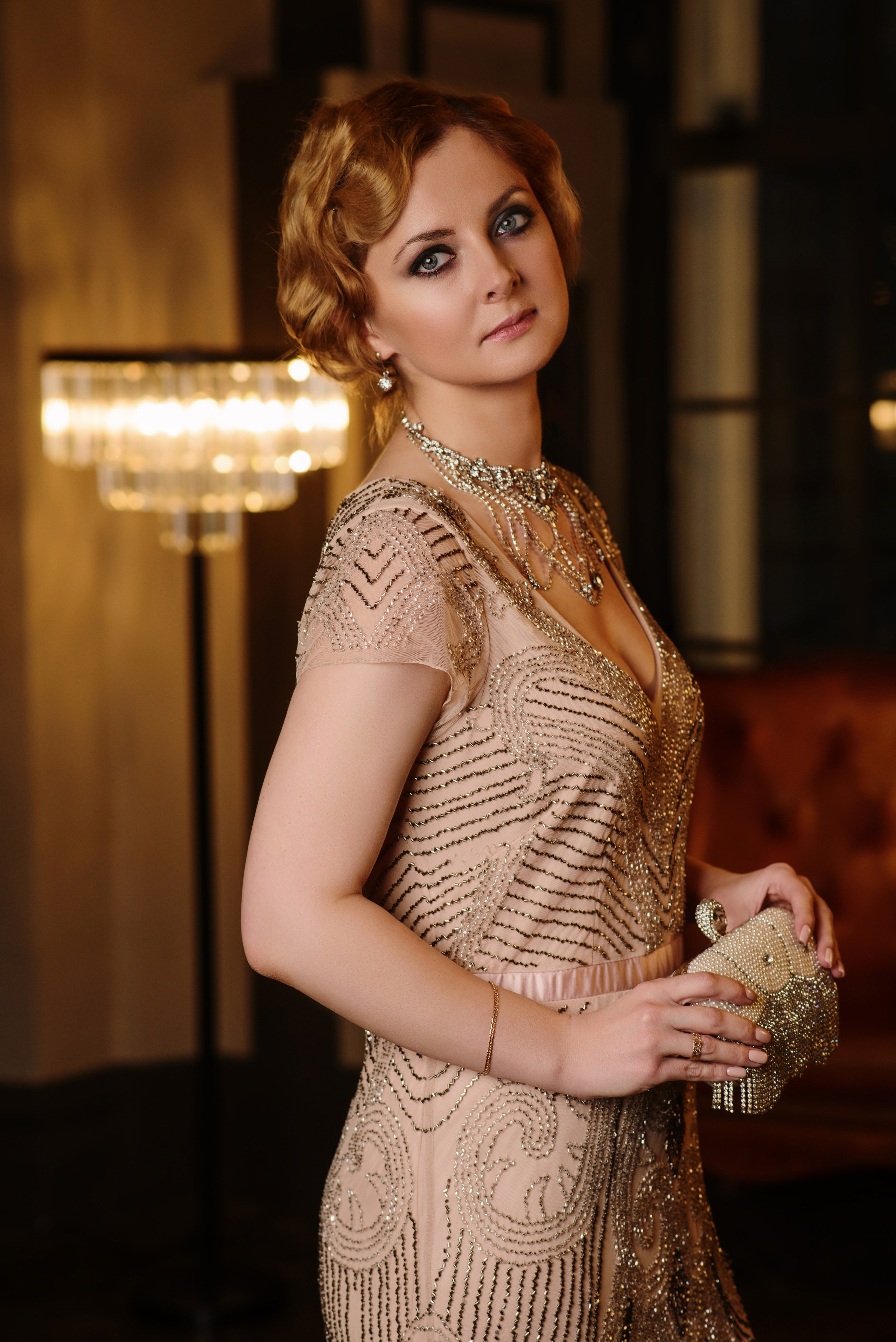 Портретная фотосессия женщины в платье с пайетками с вечерней сумочкой