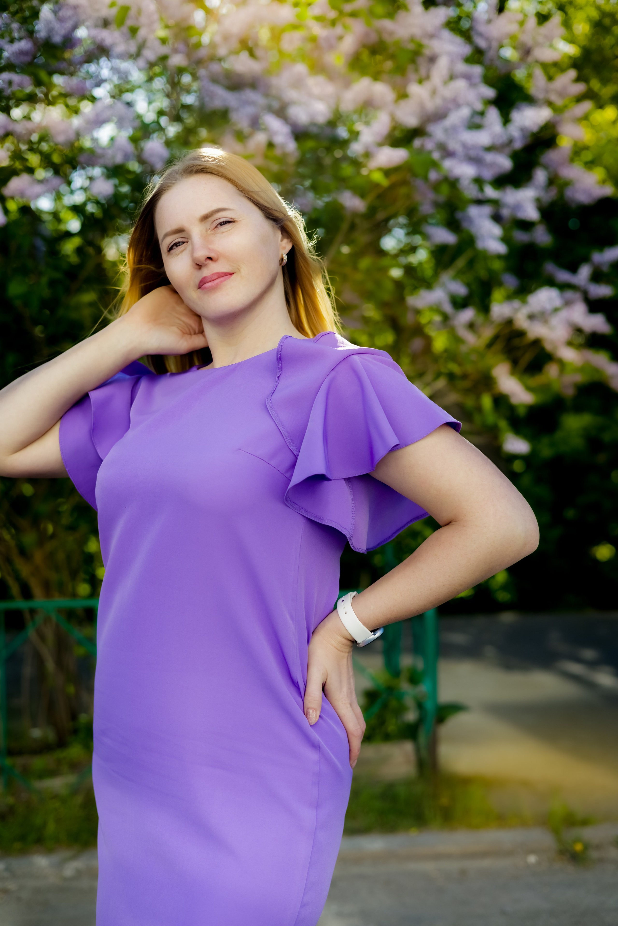 Женщина в белом платье на фоне цветущего поля и облачного неба