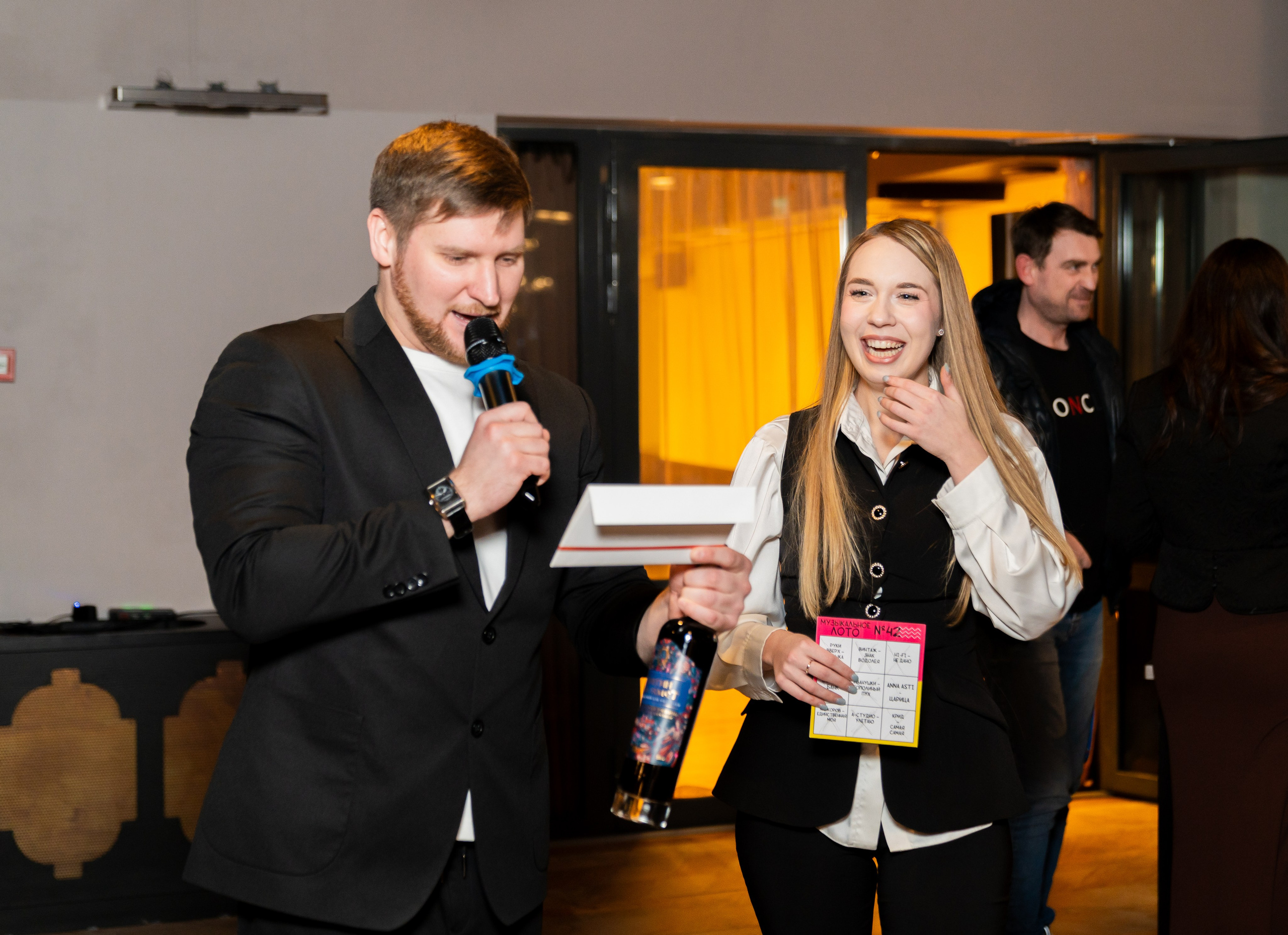 едущий вручает бутылку вина и лотерейный билет победительнице на корпоративном вечере в Radisson Sonya. Фото Евгения Мальцева.