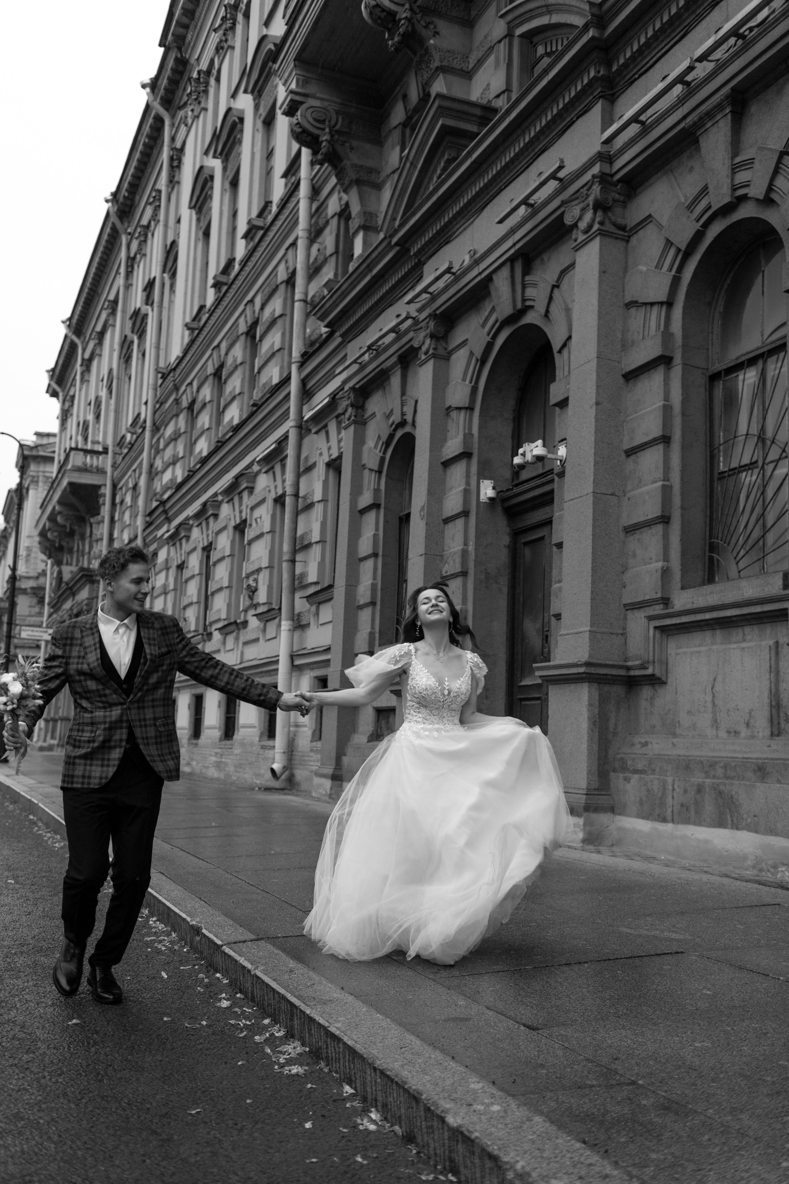 Молодожёны идут по мокрой мостовой