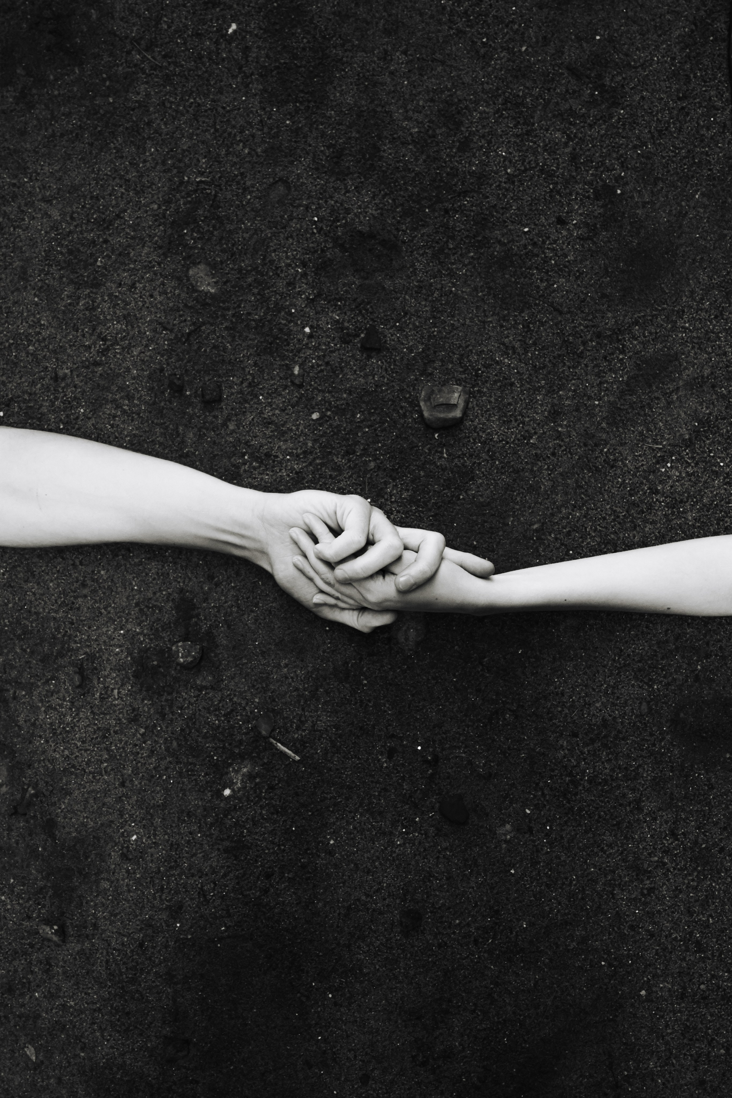 влюбленные, парочка, лежат на земле и держатся за руки, крупный кадр рук, две руки вместе, красивый свет, черно-белая фотография. Фотосессия в Питере и во Владивостоке.