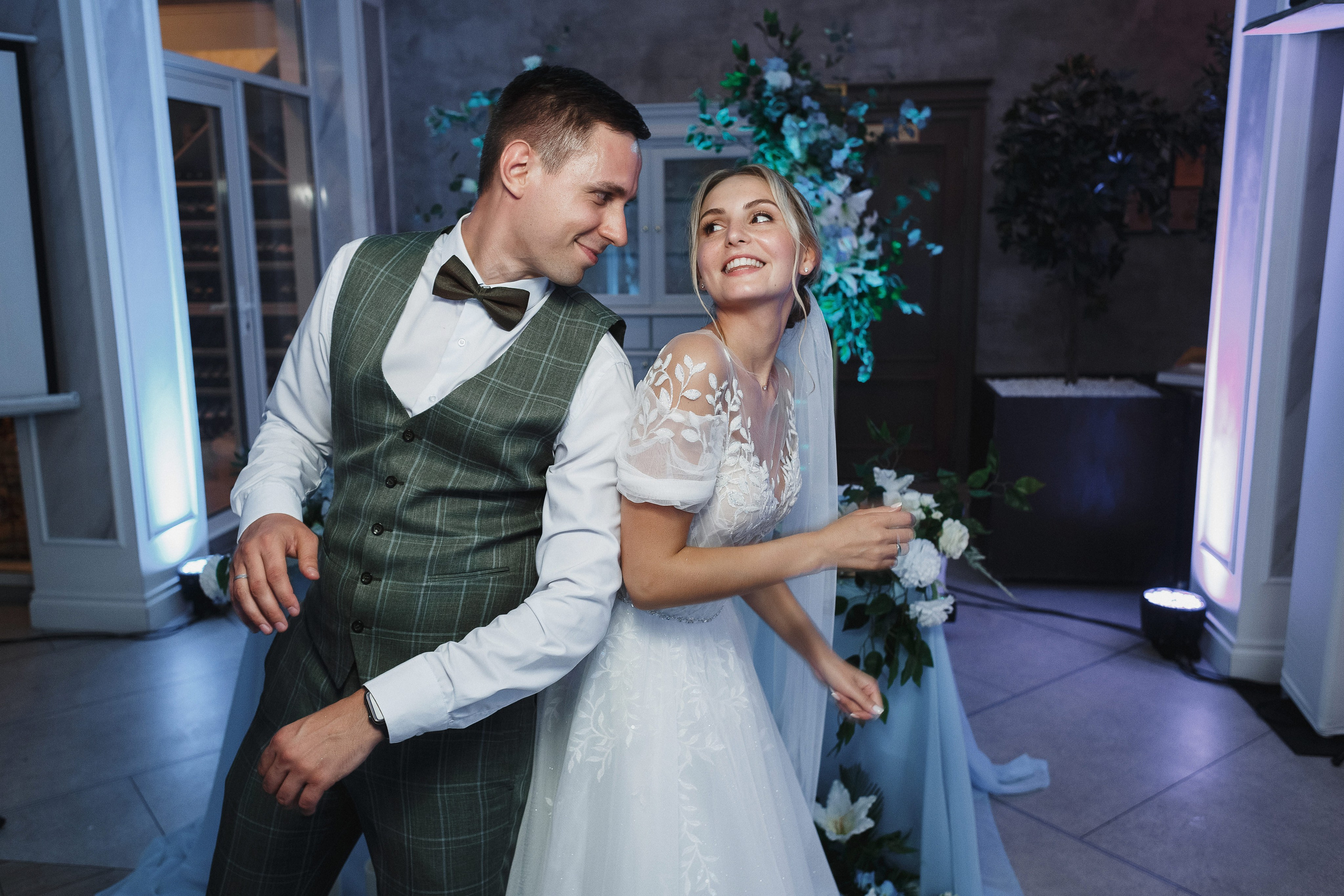 Фотография банкета в свадебный день Виктора и Анастасии в роскошном зале Голден Хорс в Таганроге: столы, украшенные цветами и свечами, счастливые гости на фоне фонтана и изысканной декорации.