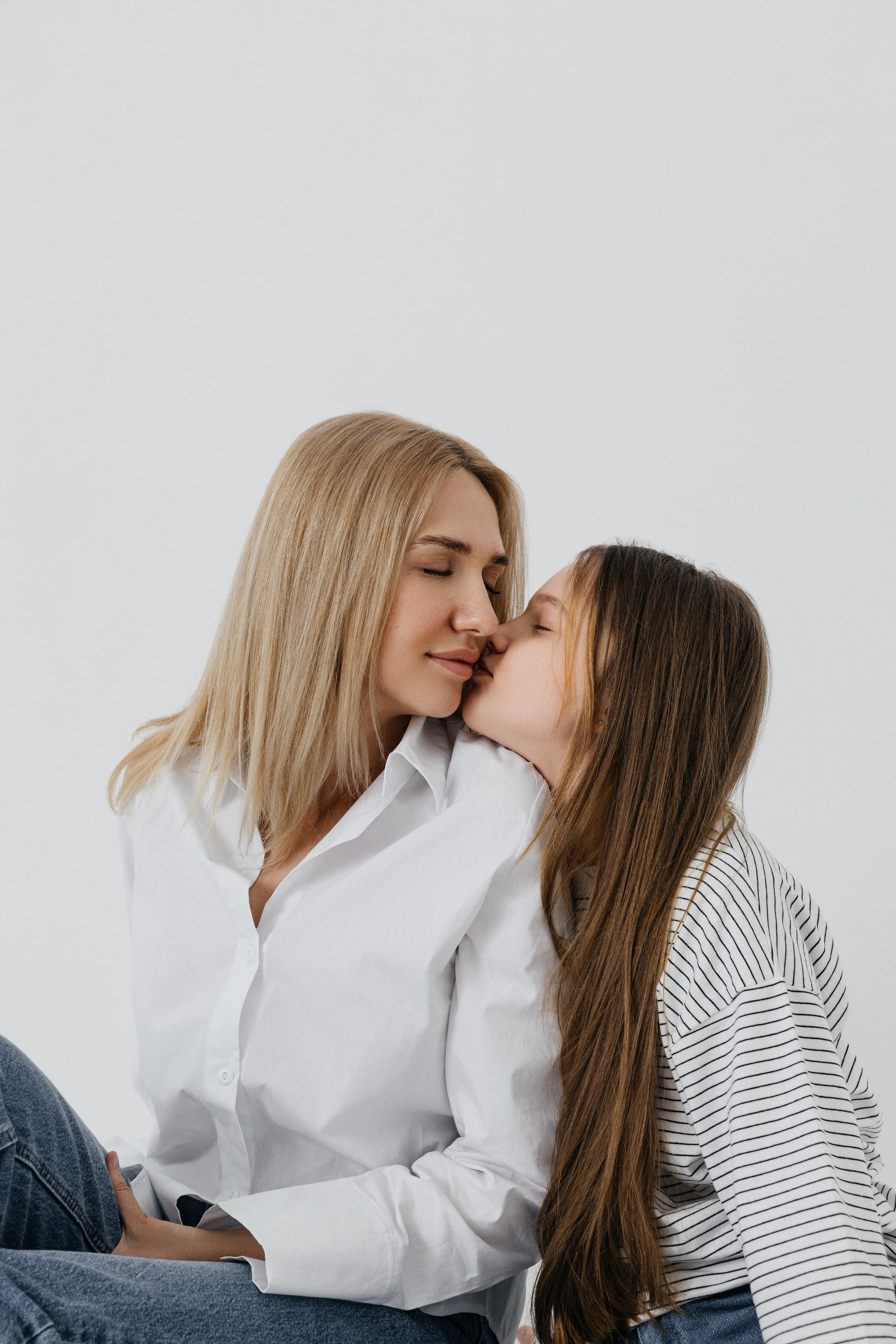 Маленькая девочка целует маму в щеку, трогательная семейная сцена