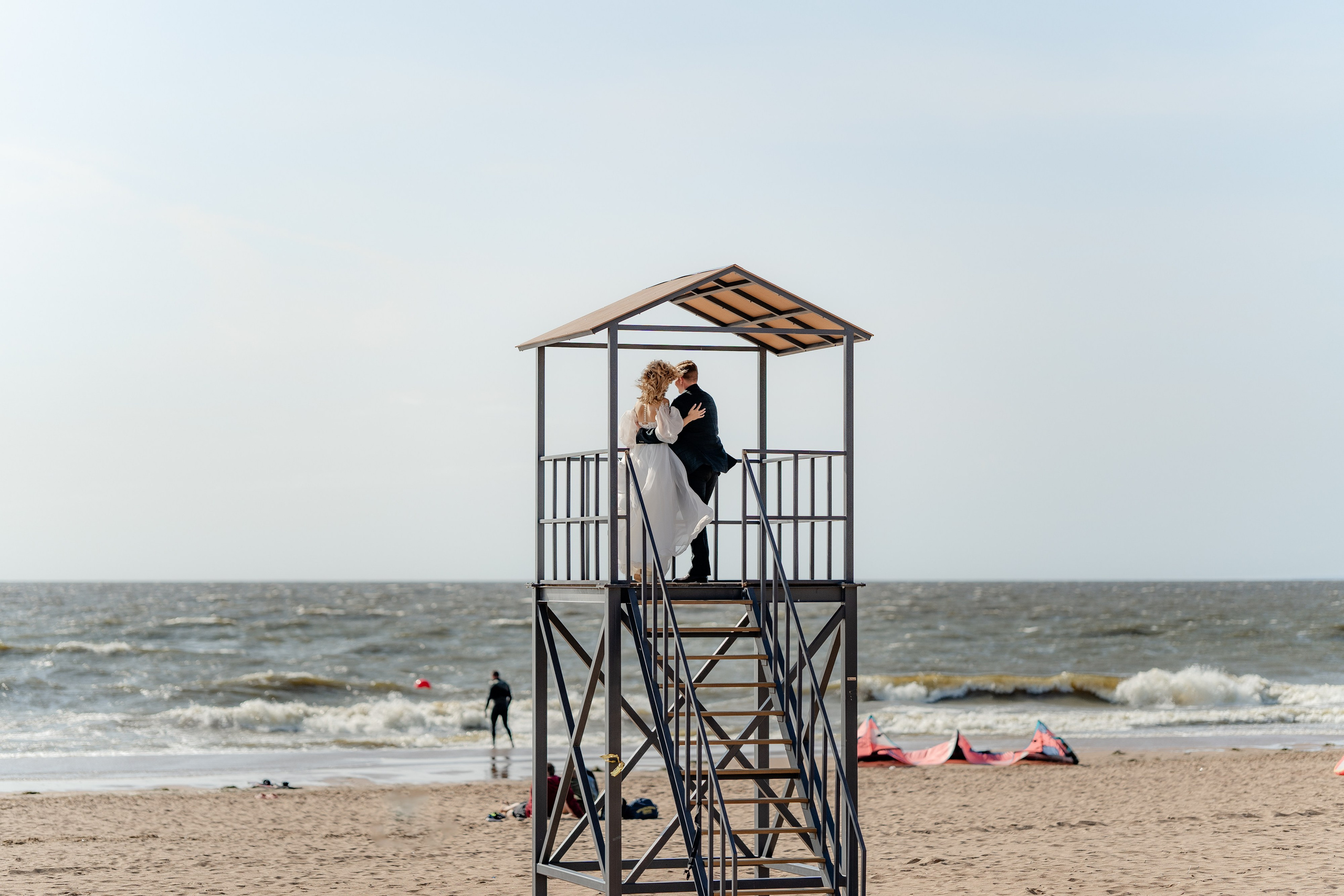 жених и невеста стоят на вышке на берегу финского залива курортном районе в сестрорецке