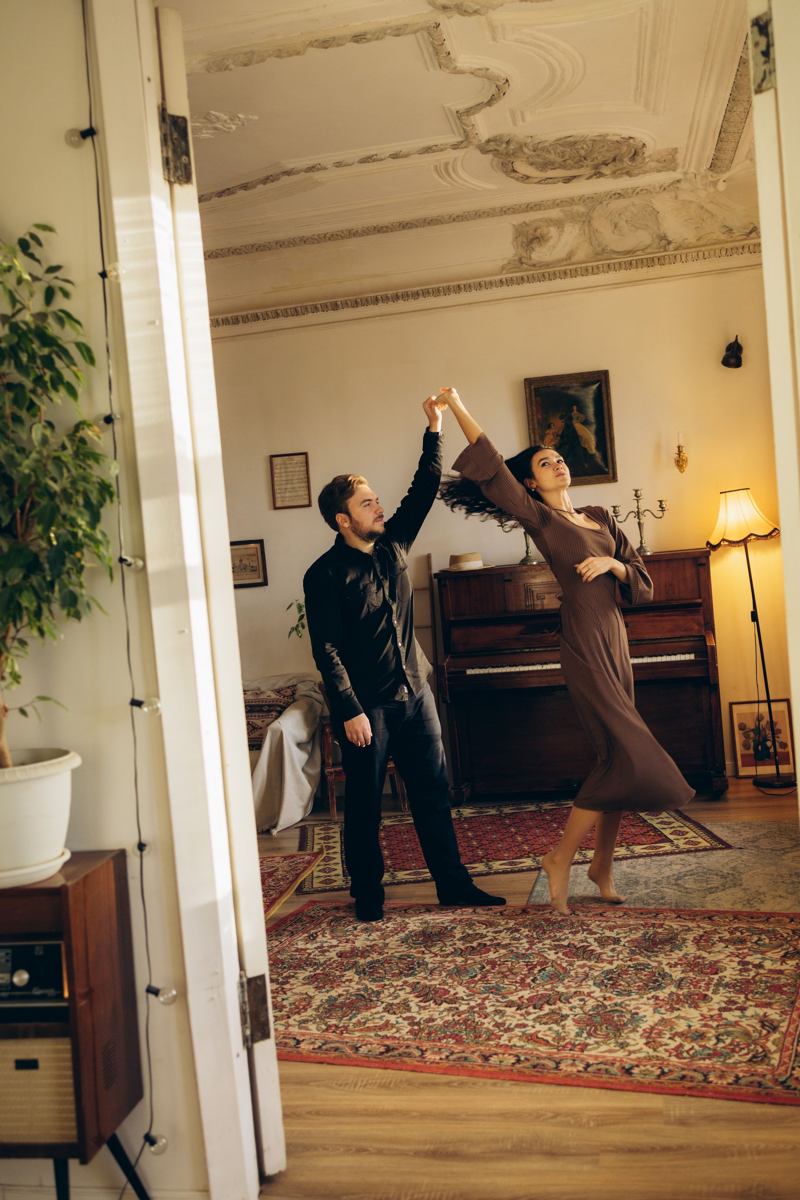 Пара смеётся и держит друг друга за руки и танцует на студийной love story