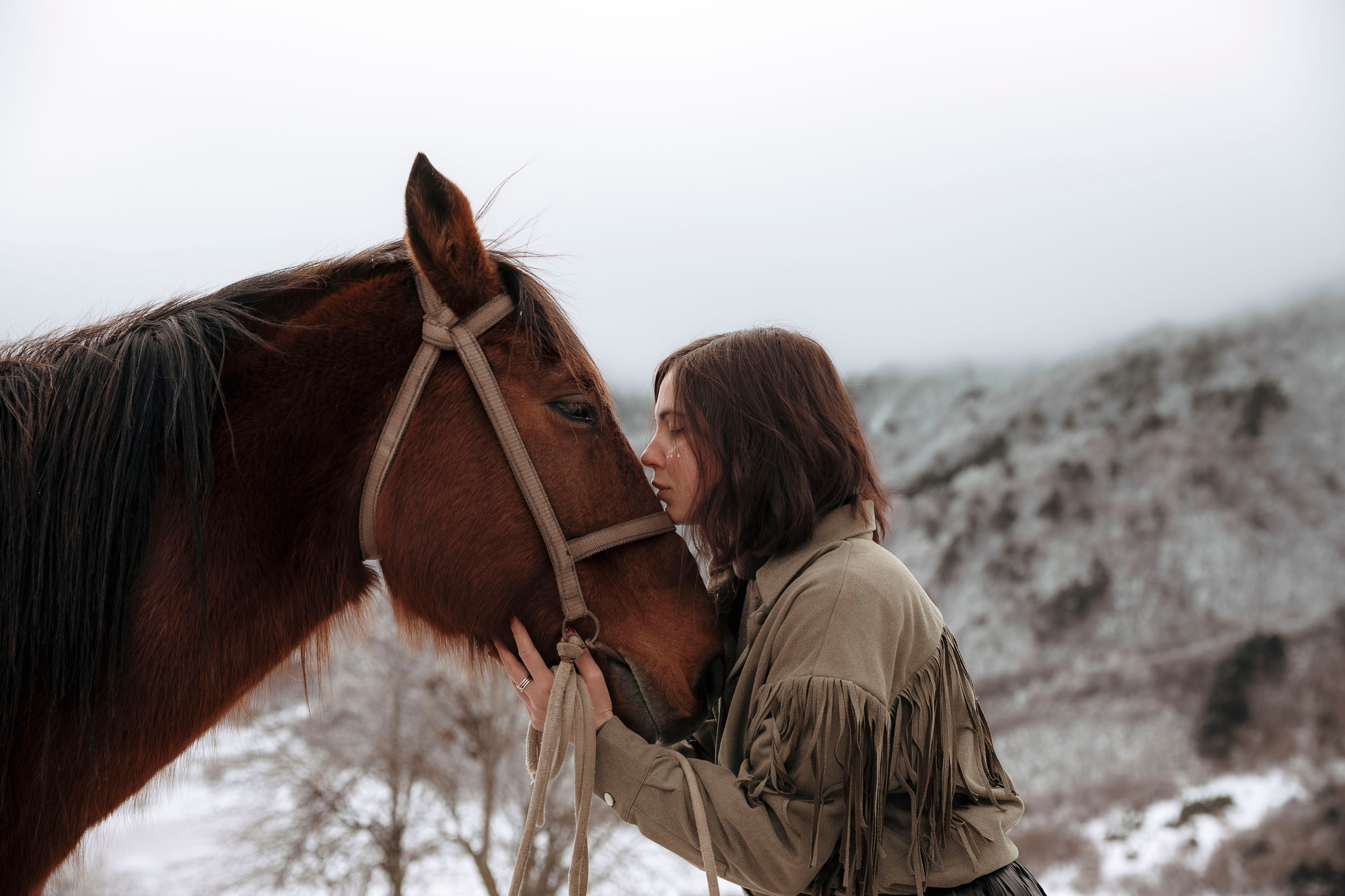 Весенняя фотография с лошадью на фоне заснеженных гор в пасмурную  погоду,  фотосессия с лошадью, фотосессия на конюшне, фотосессия в горах, фотосессия в горах с лошадью, фотосессия в одежде ковбоя, в одежде индейца, фотосессия летом, фотосессия осенью, фотосессия в Осетии 