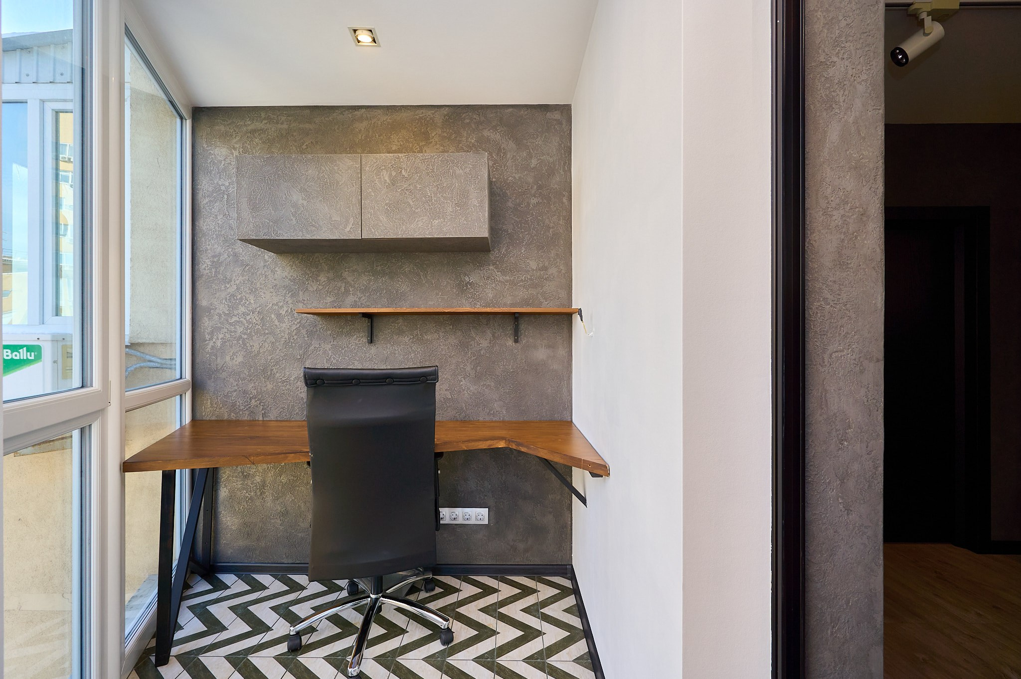 балкон с панорамными окнами стол деревянный и кресло  черное 