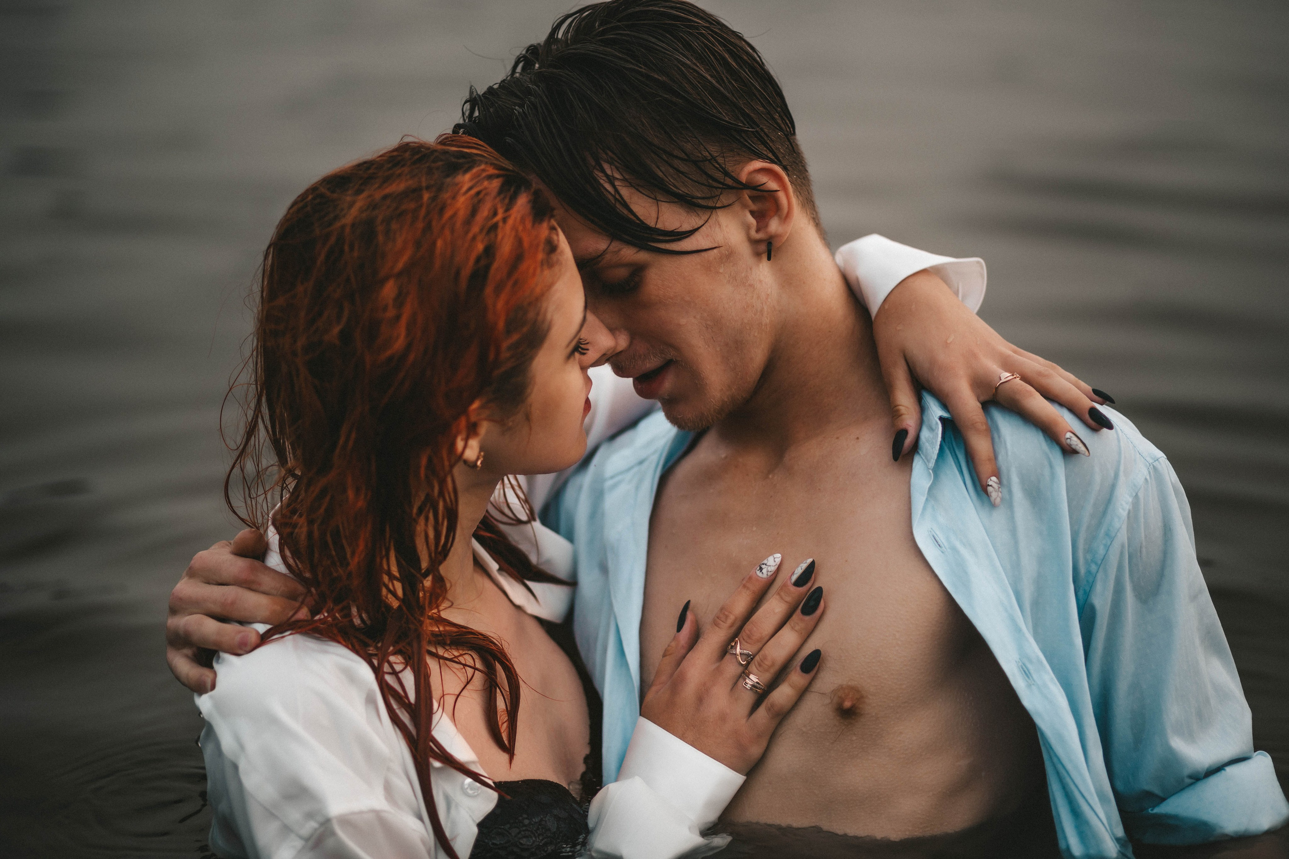 пара целуется в воде на озере