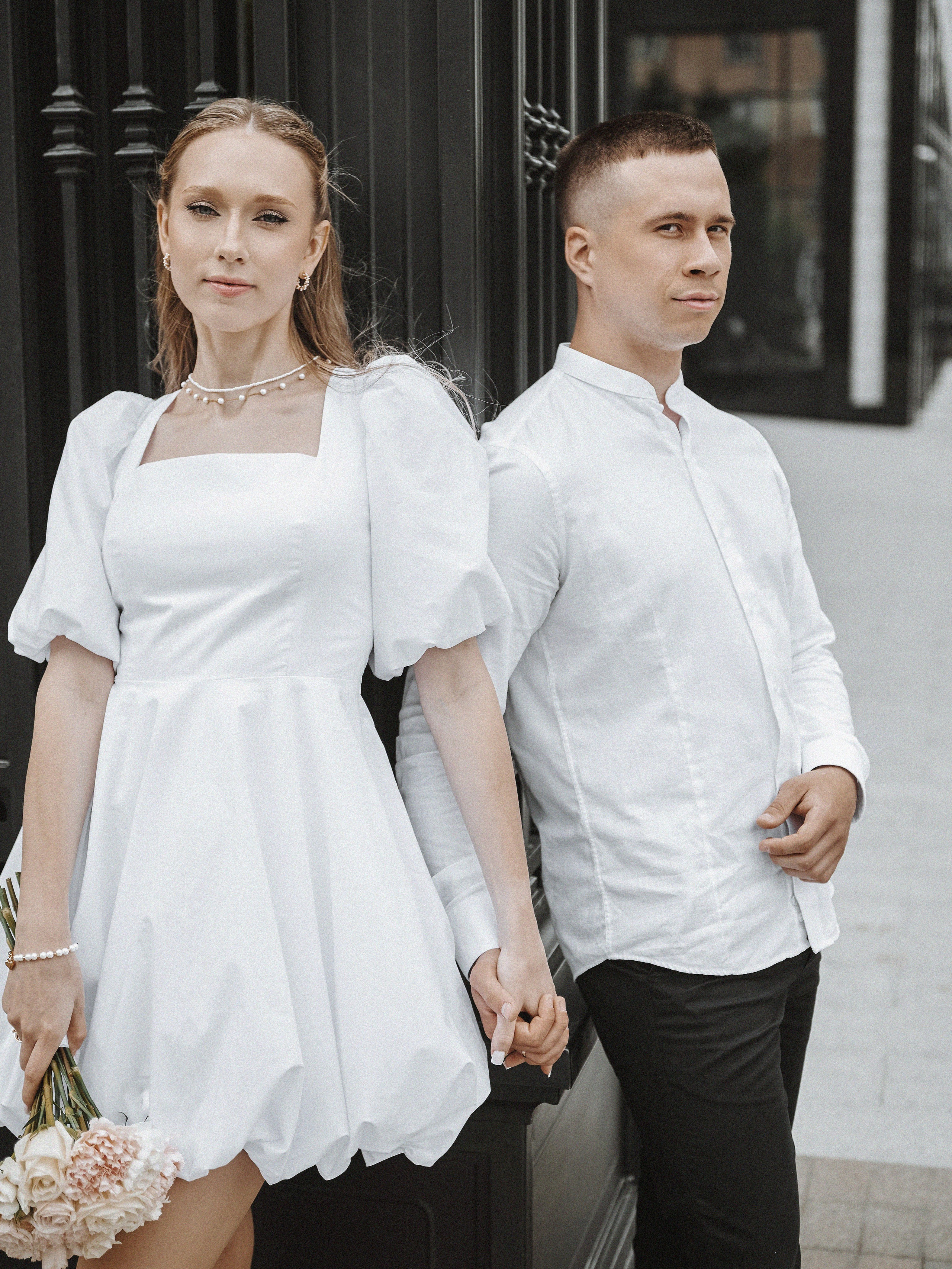 Молодожёны улыбаются на фоне кирпичной стены жилого комплекса Ричмонд.