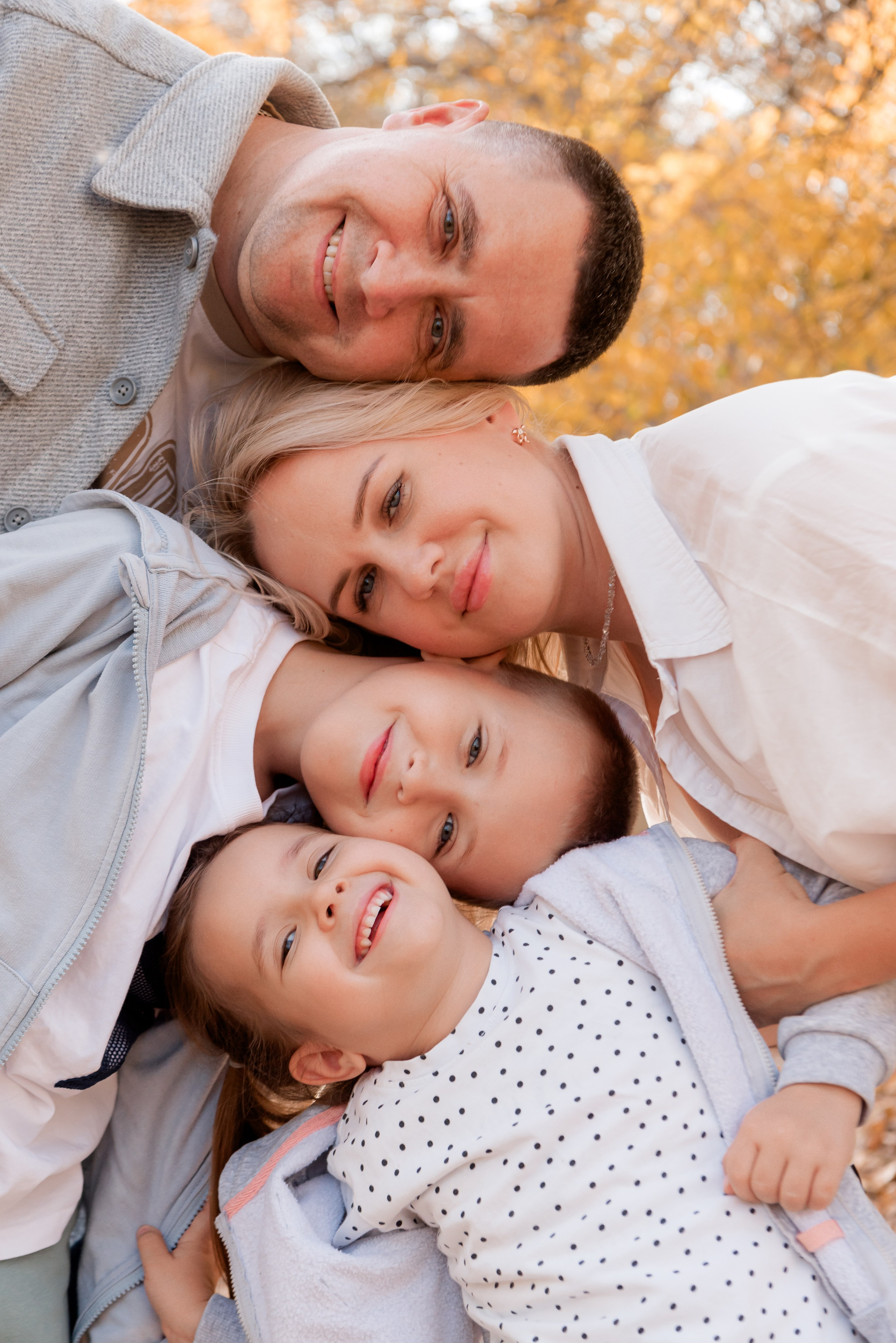 Семейный портрет осенью на природе папа мама сын и дочка пирамиды сложили головы