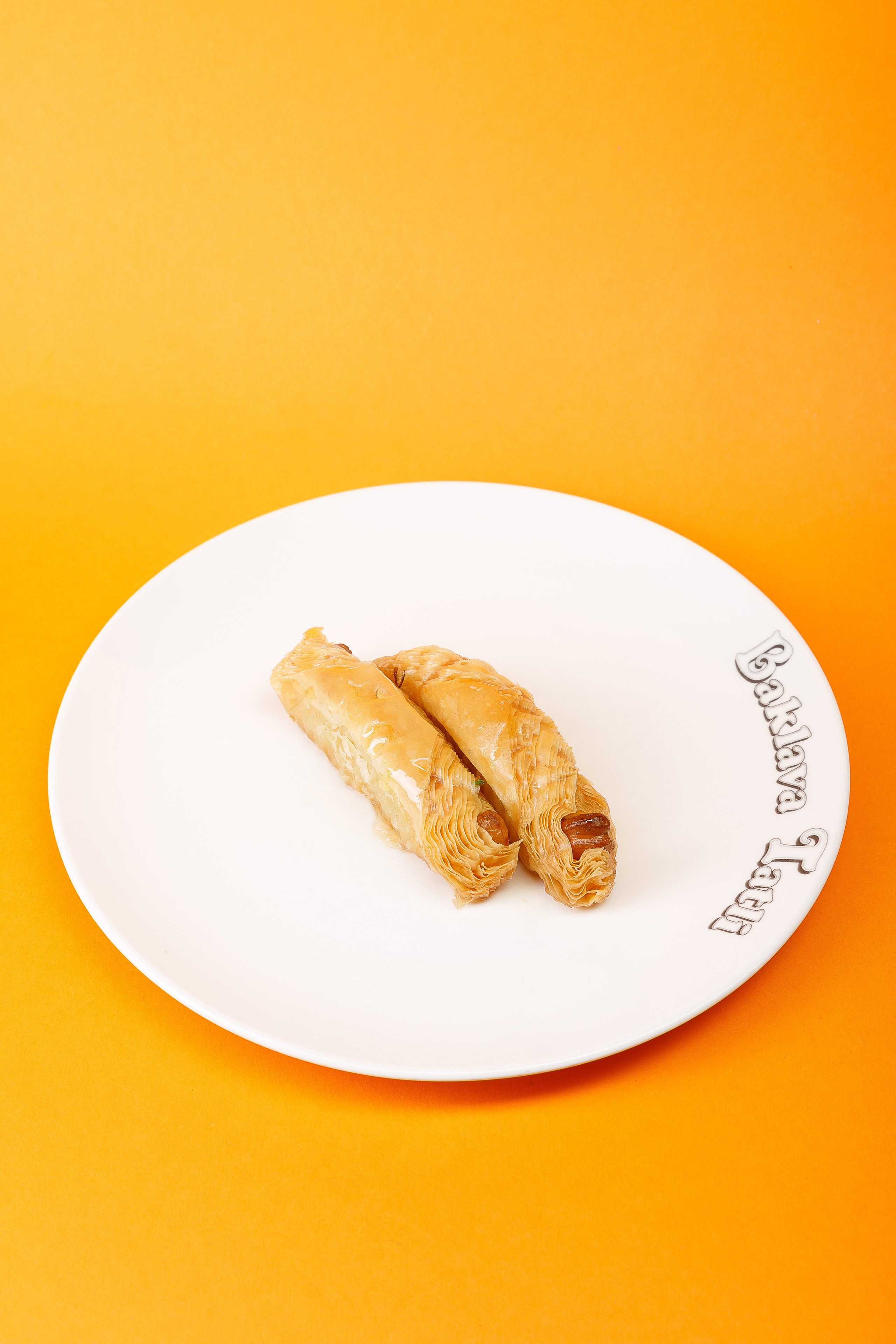 Пахлава на тарелке оранжевый фон