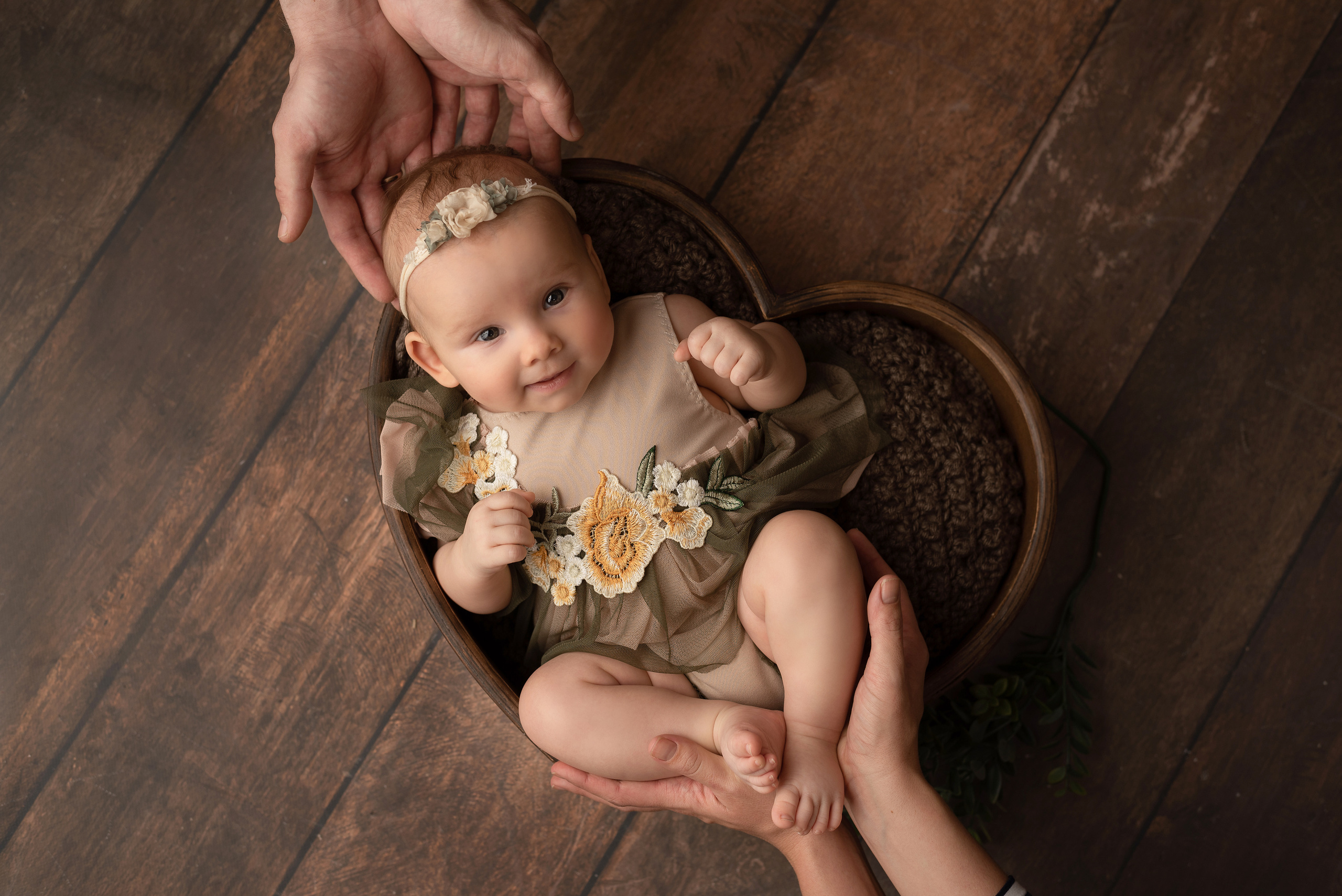 Baby in a green dress with her father in her arms