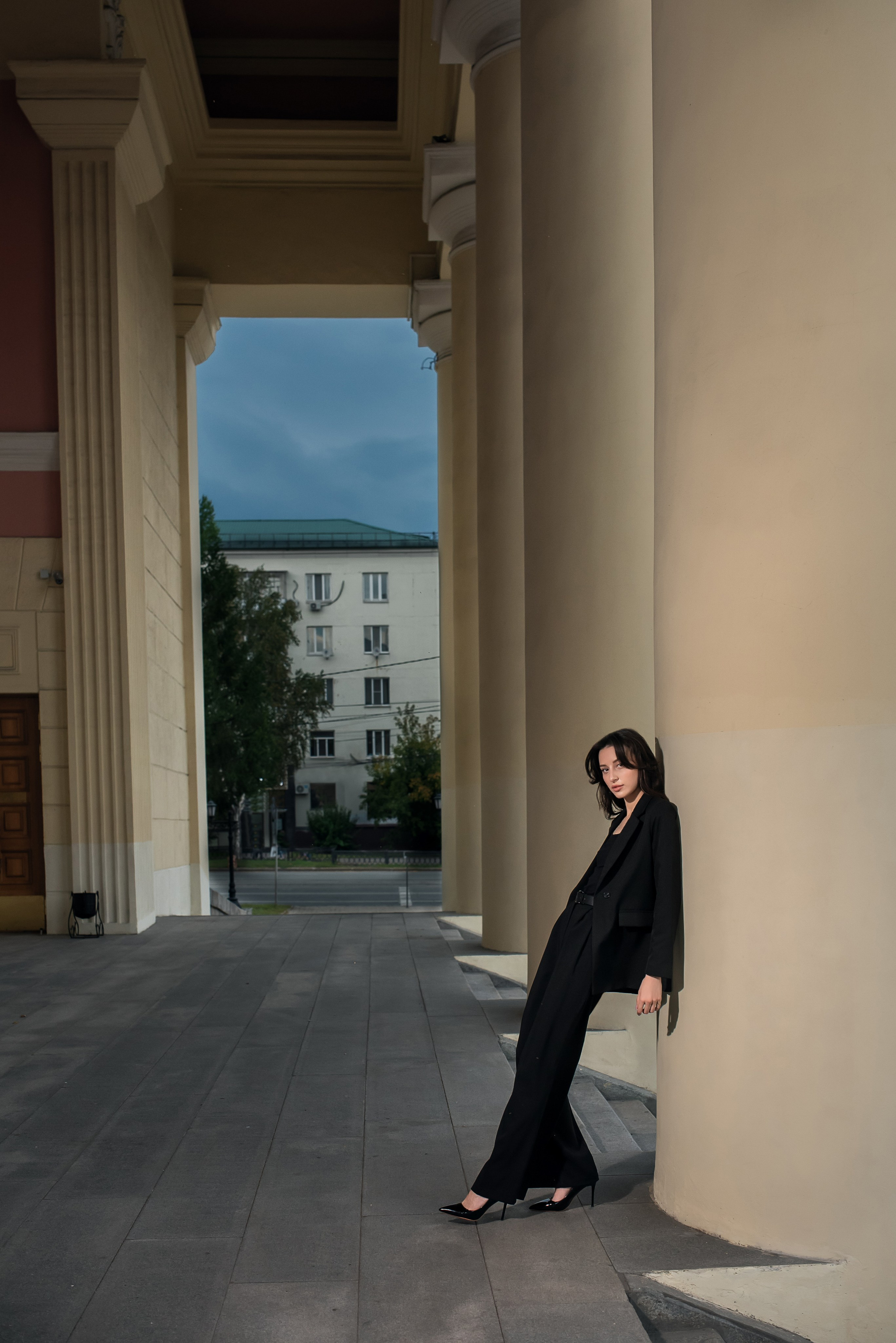 Городская фотосессия. Девушка стоит на фоне красивой архитектуры города