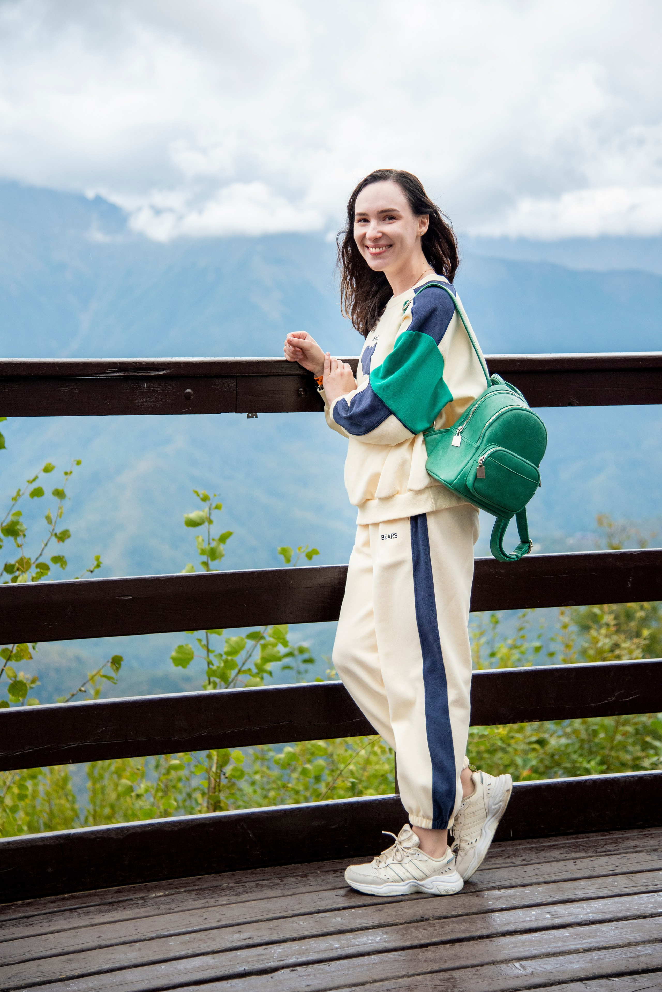 Брюнетка, на фоне гор. Красная поляна, спортивный костюм, рюкзачёк