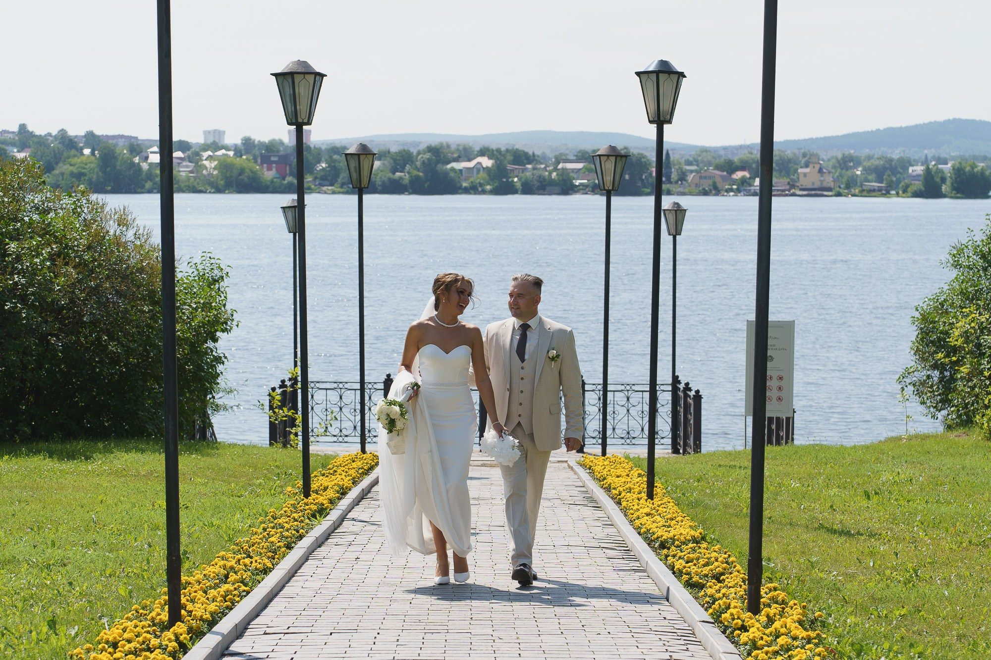 Прогулка пары по живописной локации рядом с парком и набережной  — естественные моменты свадебной фотосессии. Фото от Свадебного фотографа в Екатеринбурге Евгения Карася