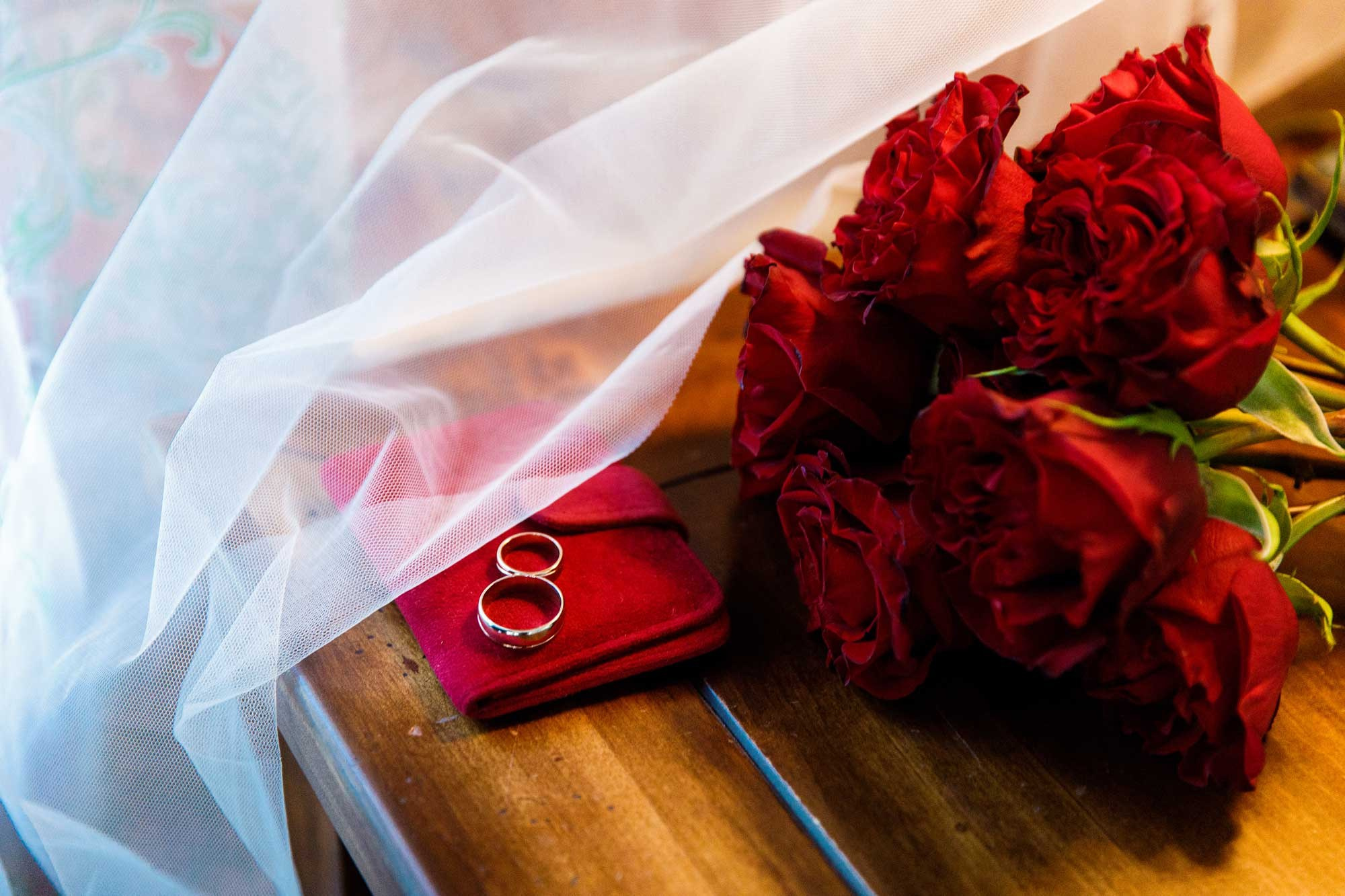 Кольца и свадебный букет из красных роз