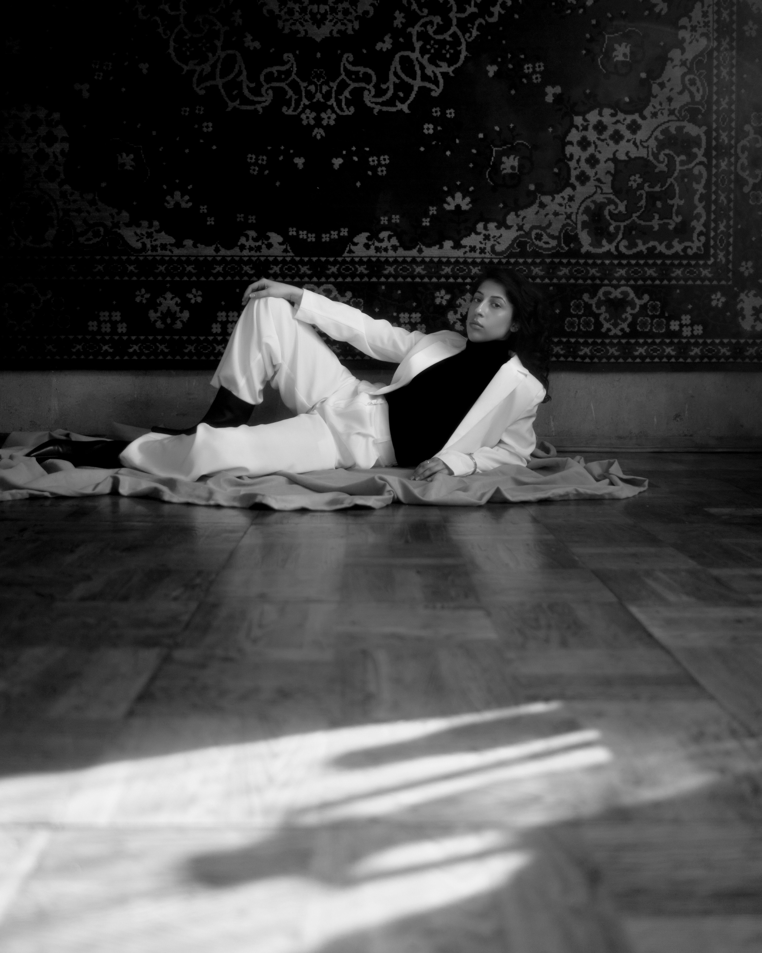 Черно-белая женская фотосессия от фотохудожника СПб, девушка лежит на полу у ковра