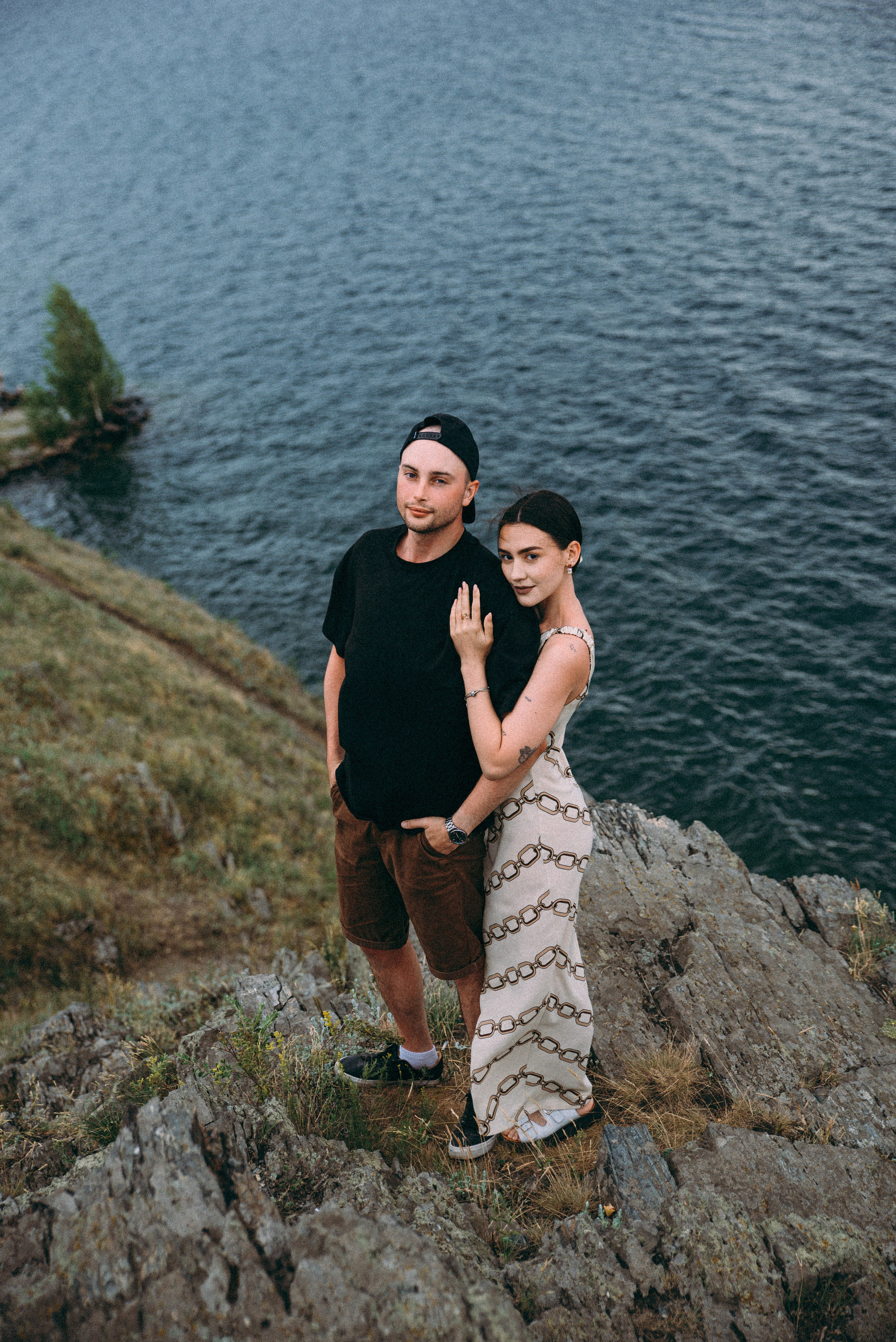 пара влюбленных красуются на берегу у обрыва