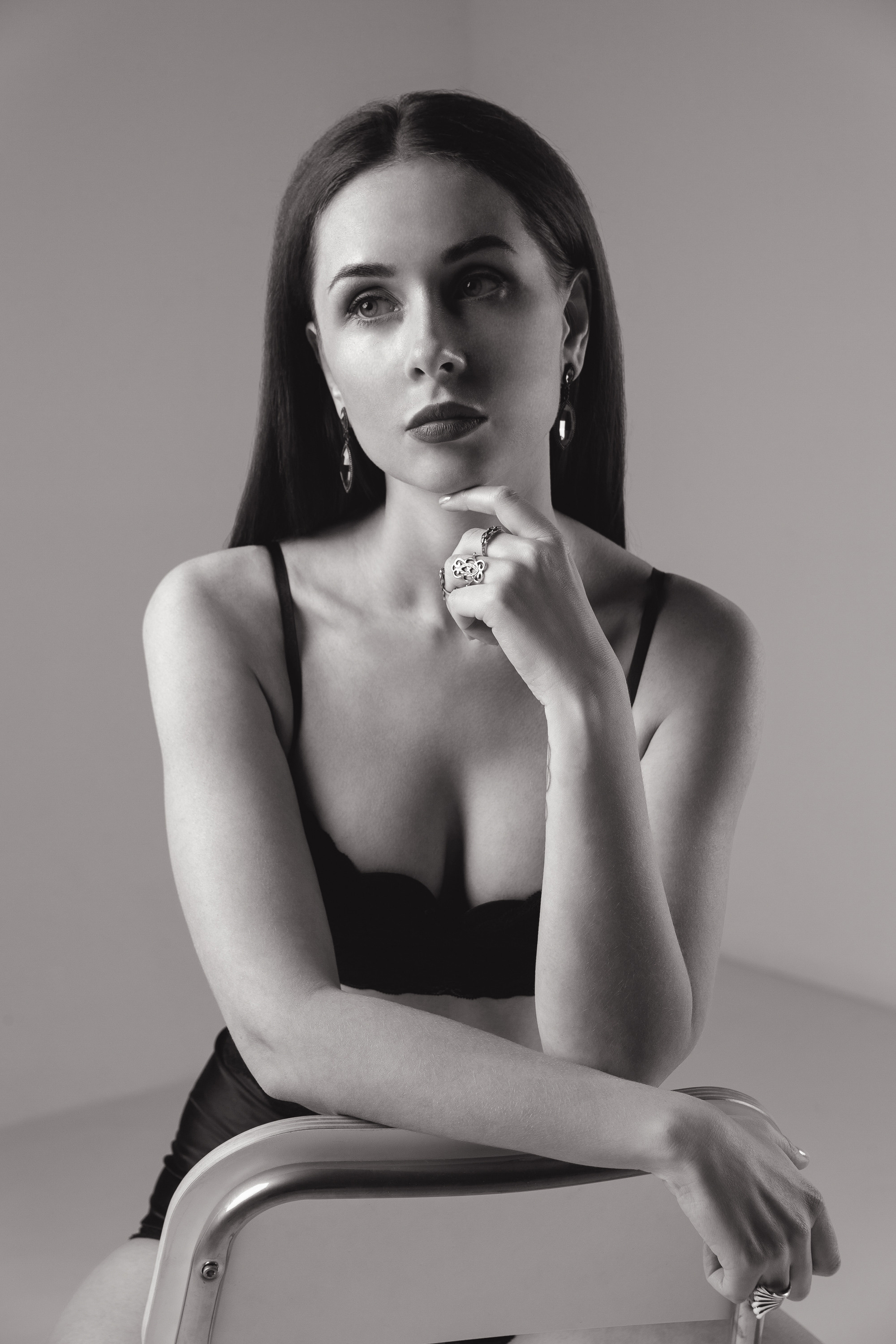 Девушка в черном боди на минималистичном фоне 