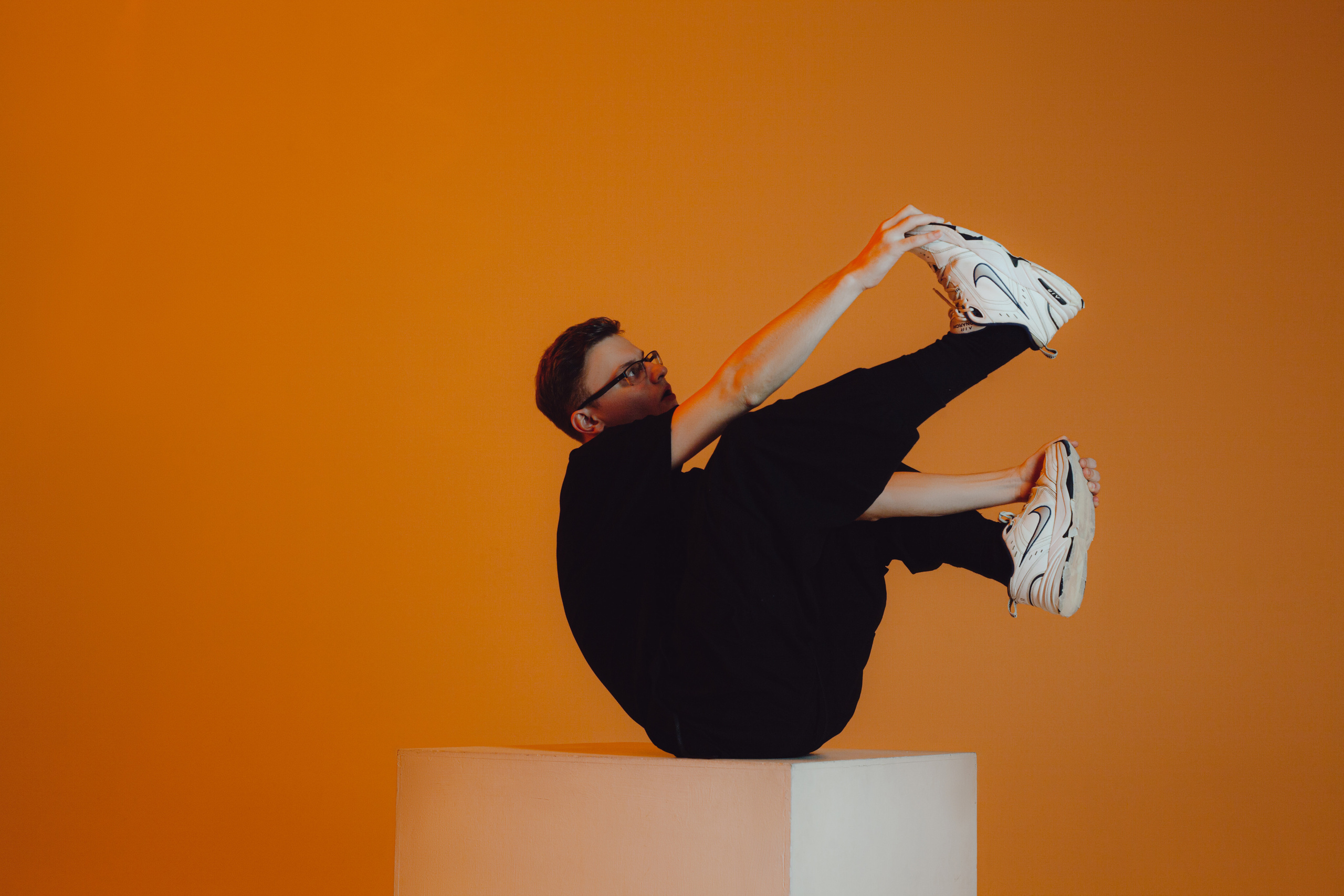 Парень в странной позе на желтом фоне