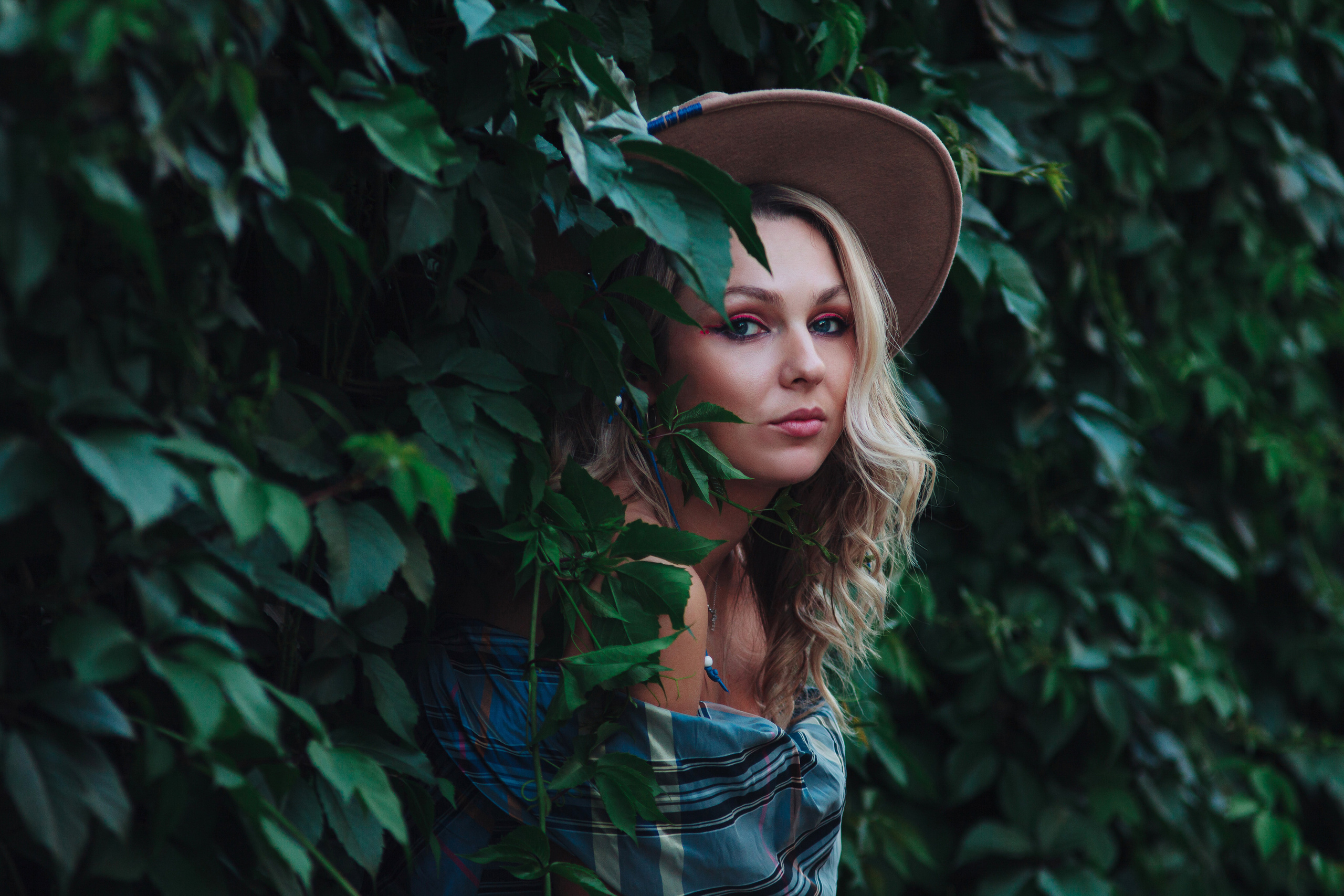 Девушка в шляпке в зеленой листве
