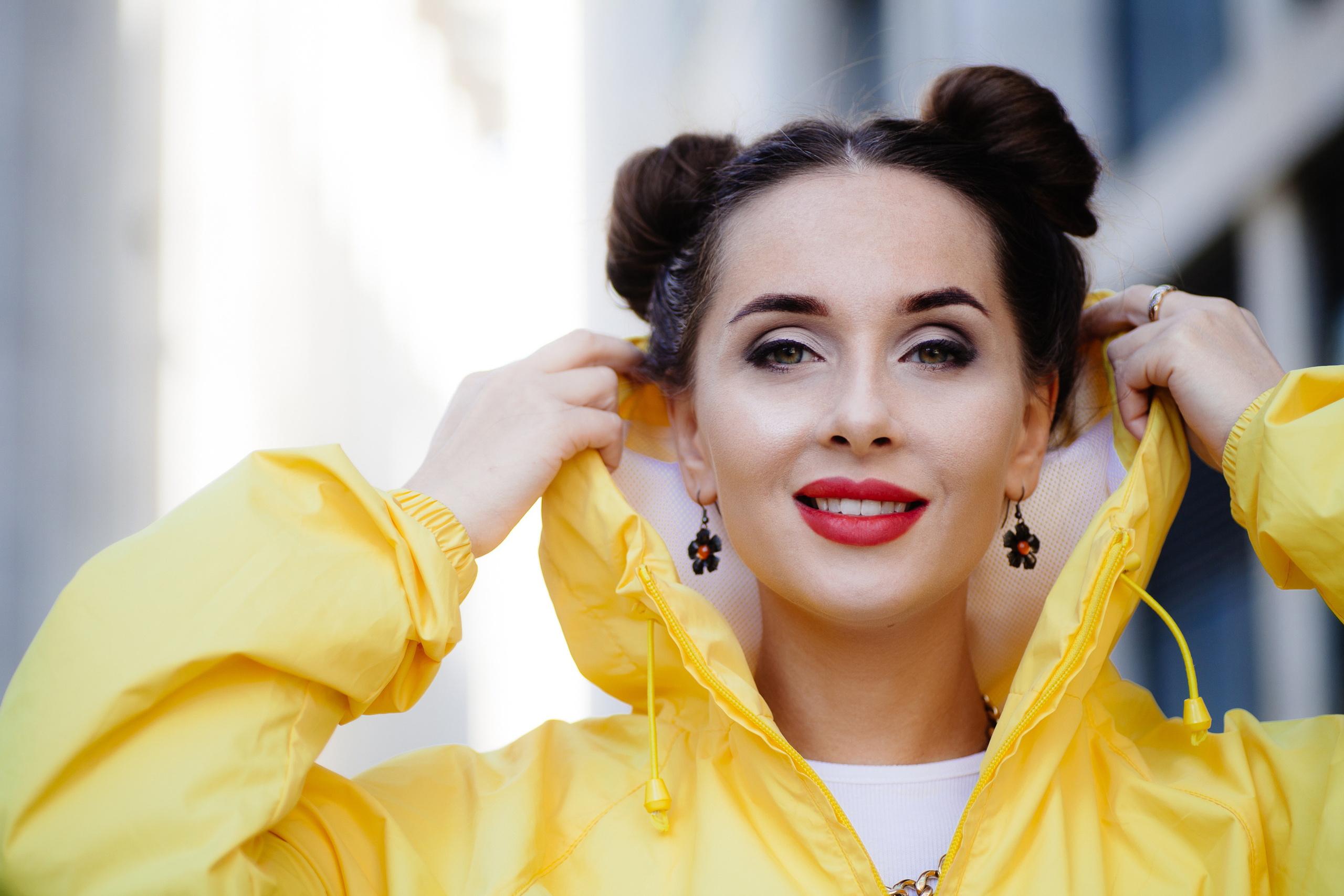 Девушка в желтой кофте с капюшоном, с забавной прической и красной помадой крупным планом