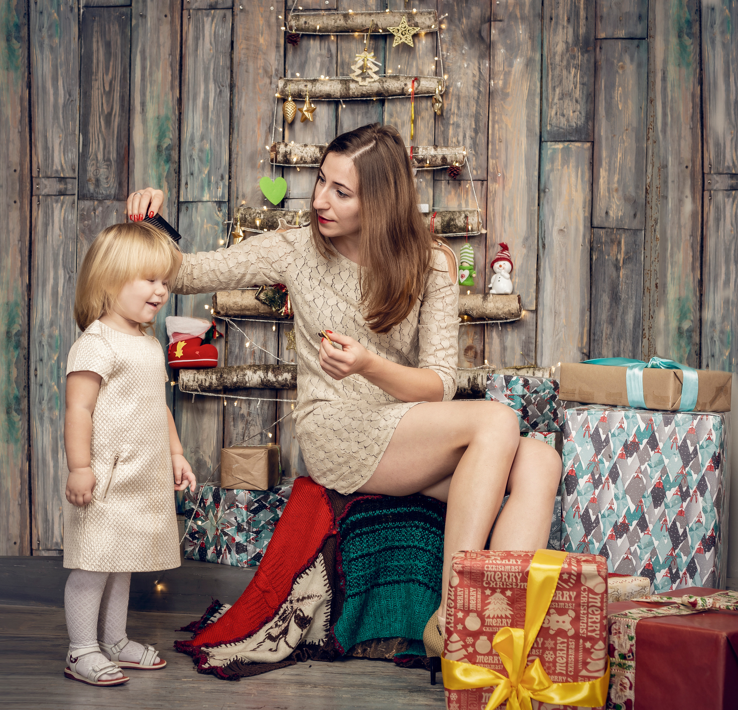 Мама и дочка. фотосессия в студии. мама расчесывает волосы