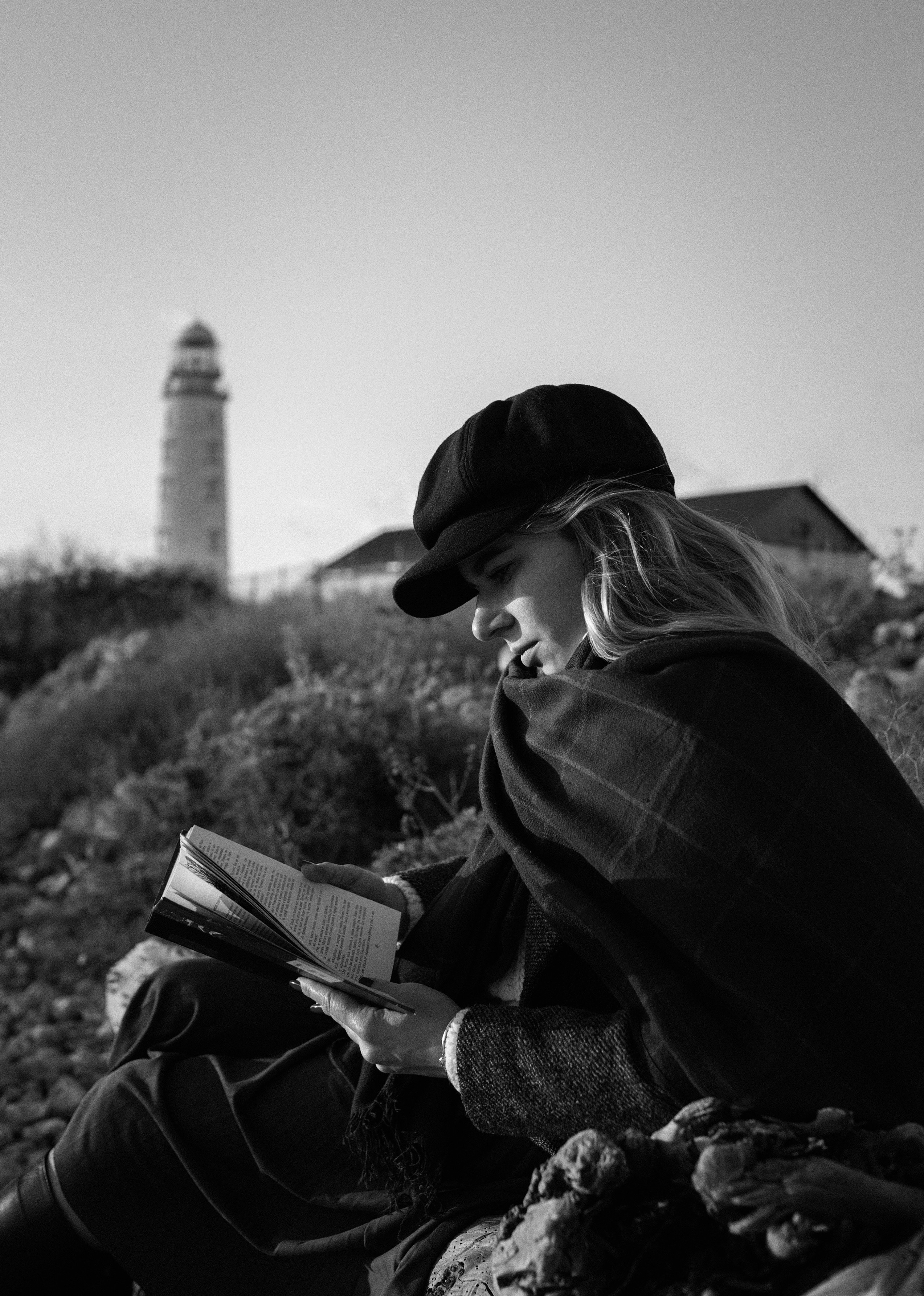 Портрет девушки с книгой у моря на фоне маяка