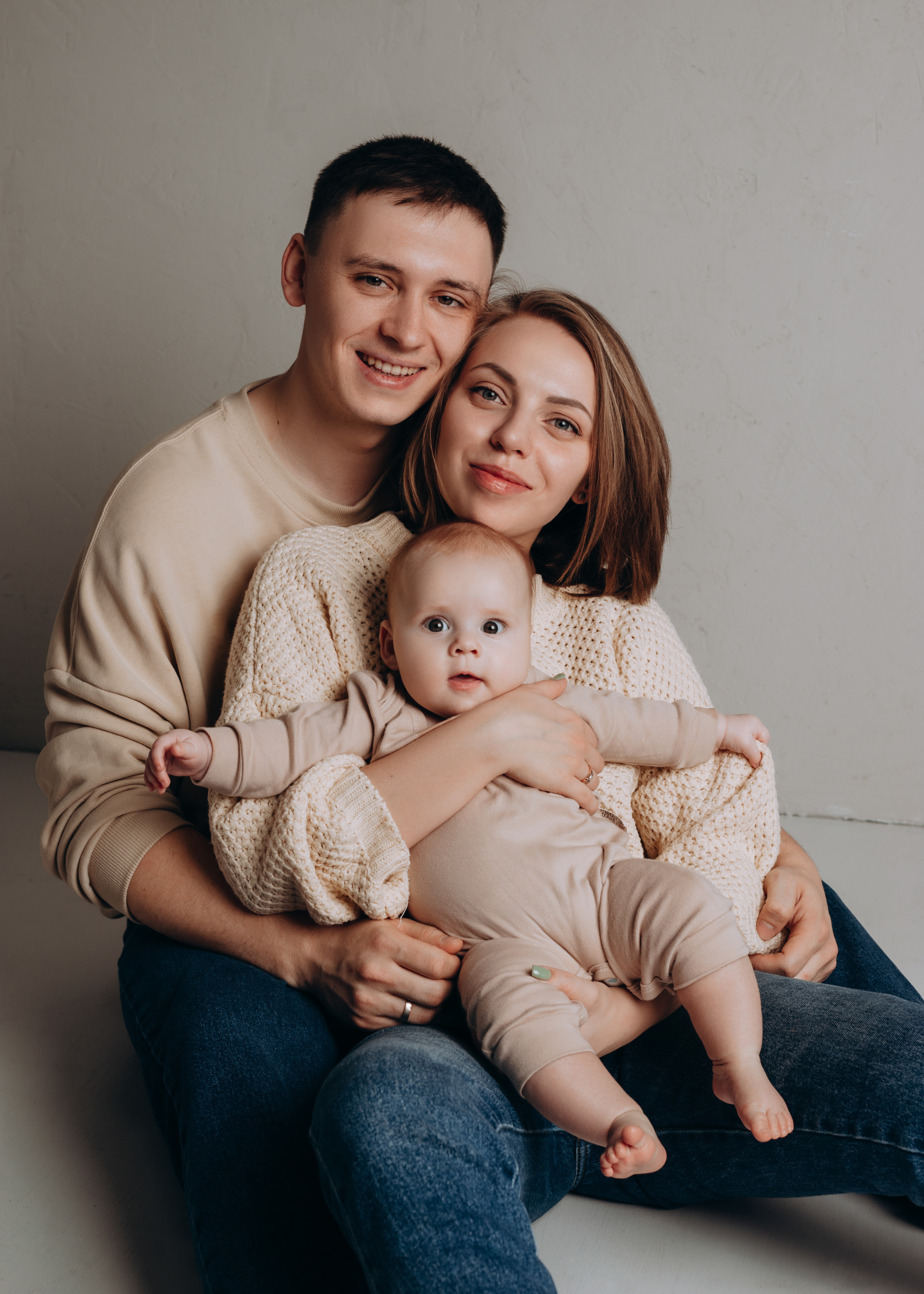 Семейный портрет мамы, папы и малыша в фотостудии