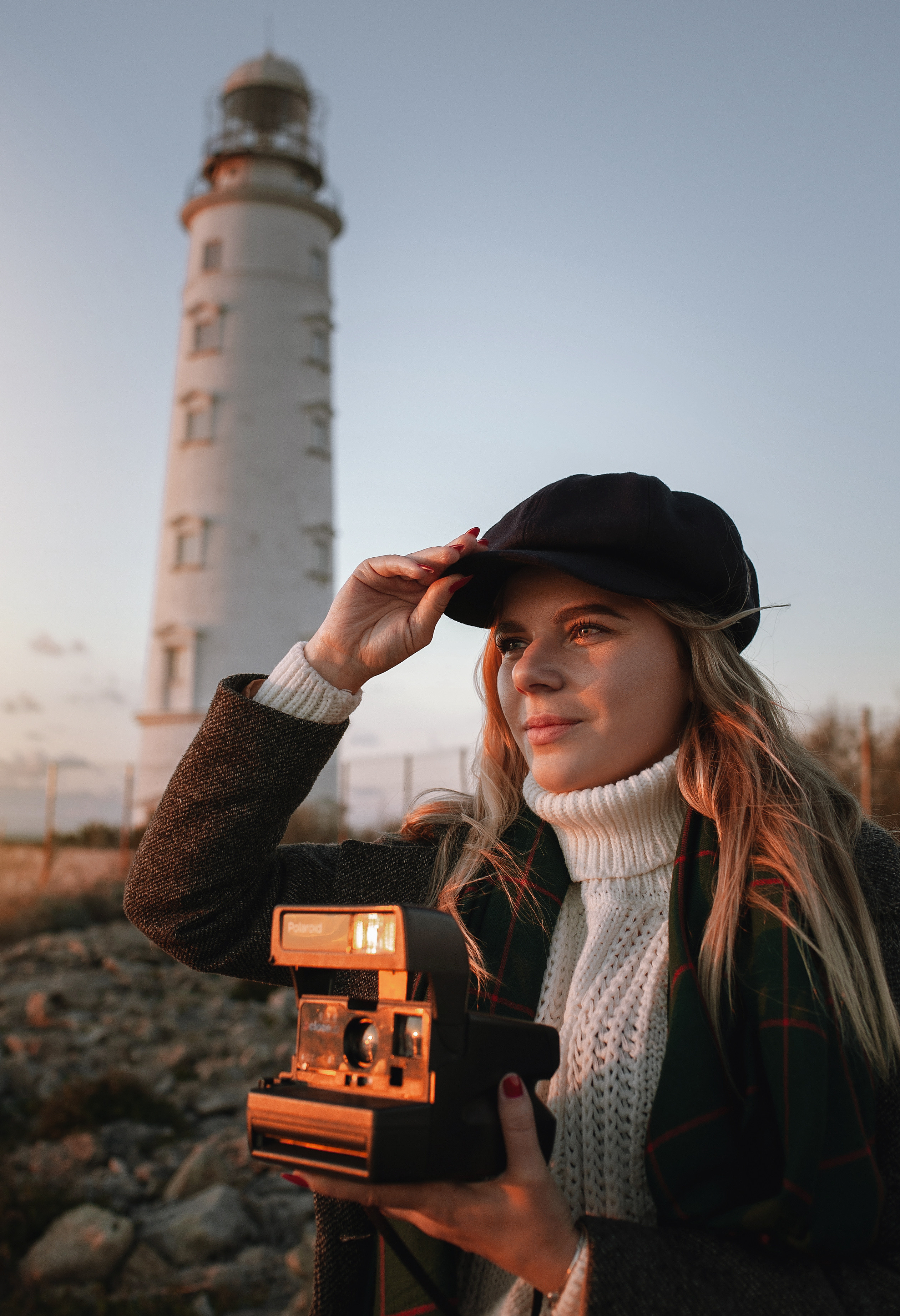 Девушка в фетровой кепке с фотоаппаратом polaroid на закате у Херсонесского маяка, Севастополь, Крым