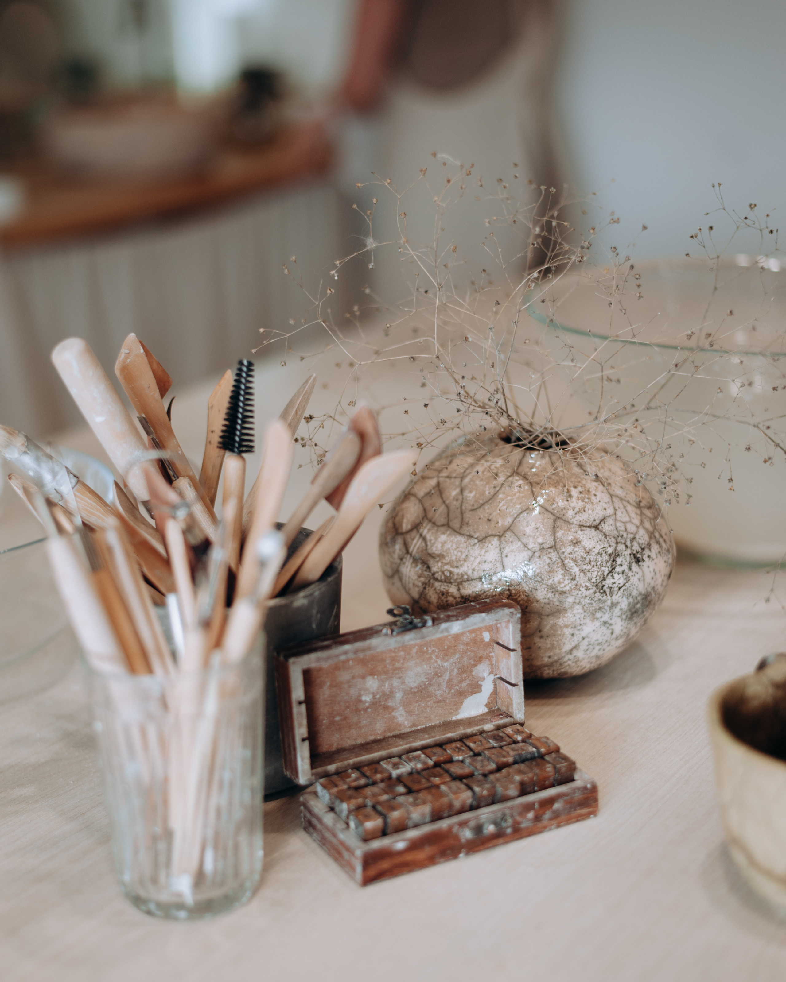 Инструменты для лепки из глины. Ваза в трещинами из белой глины с сухоцветами