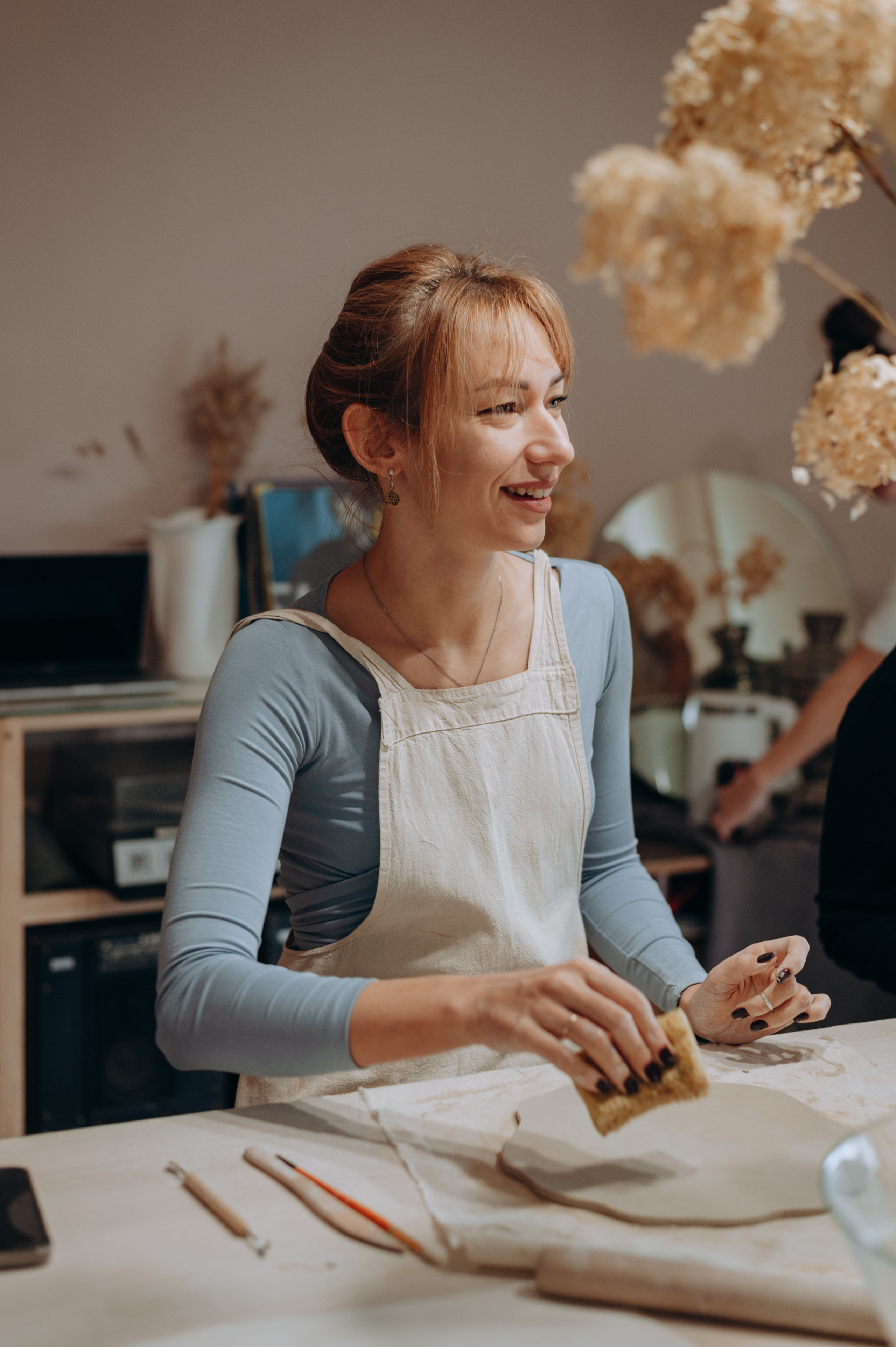 Девушка лепит из белой глины