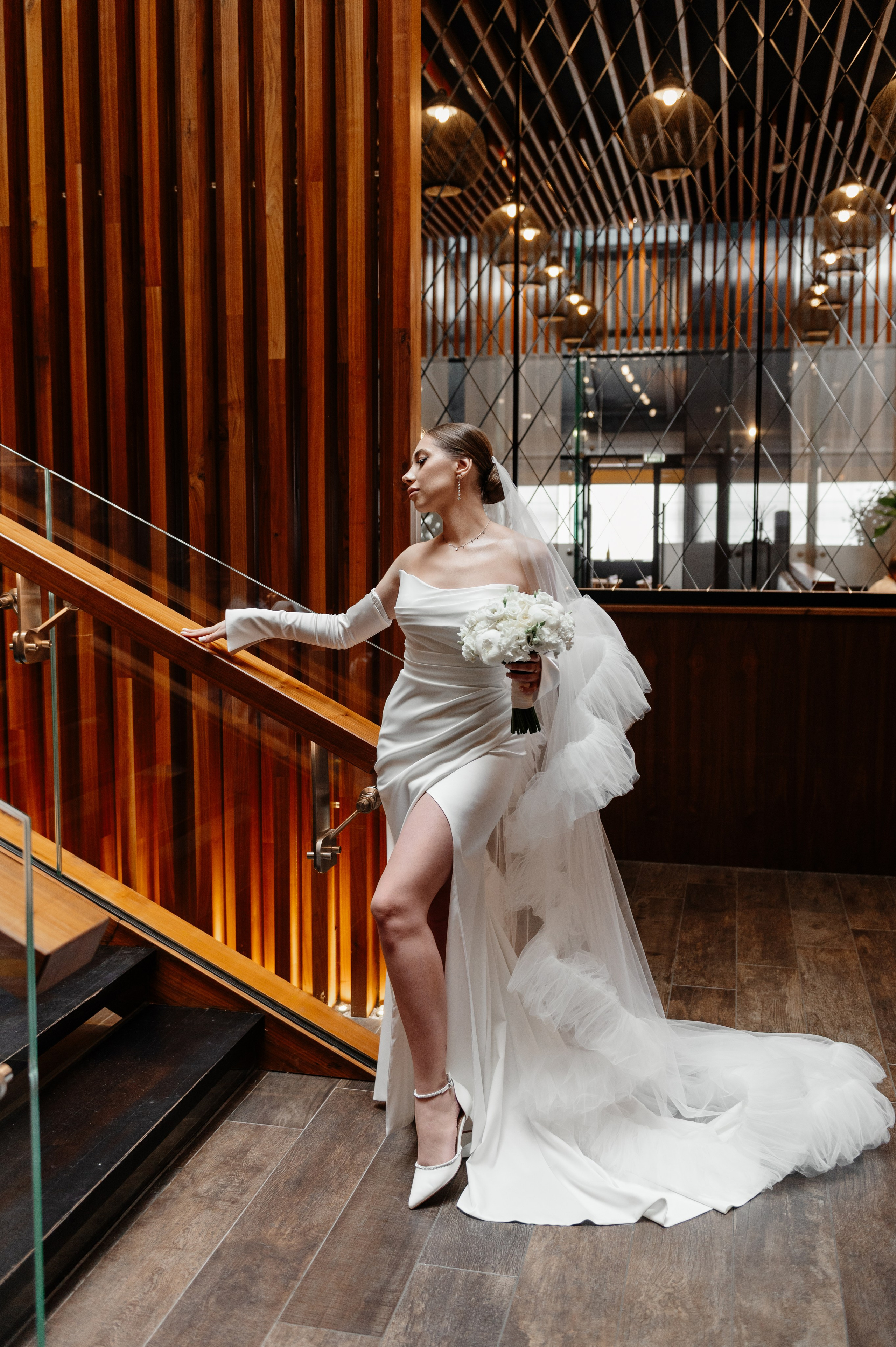 Невеста стоит у красивой лестницы в отеле Москвы.