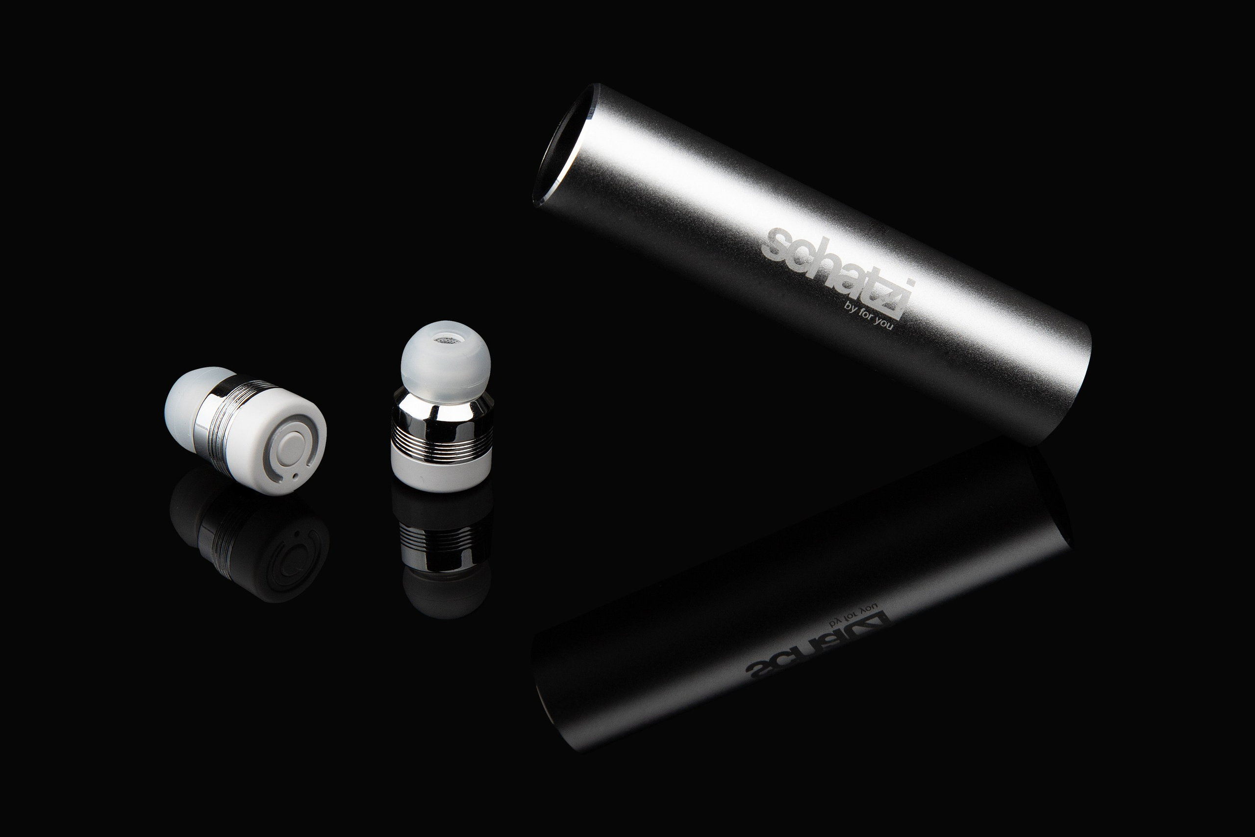 Серебристые беспроводные наушники рядом с кейсом