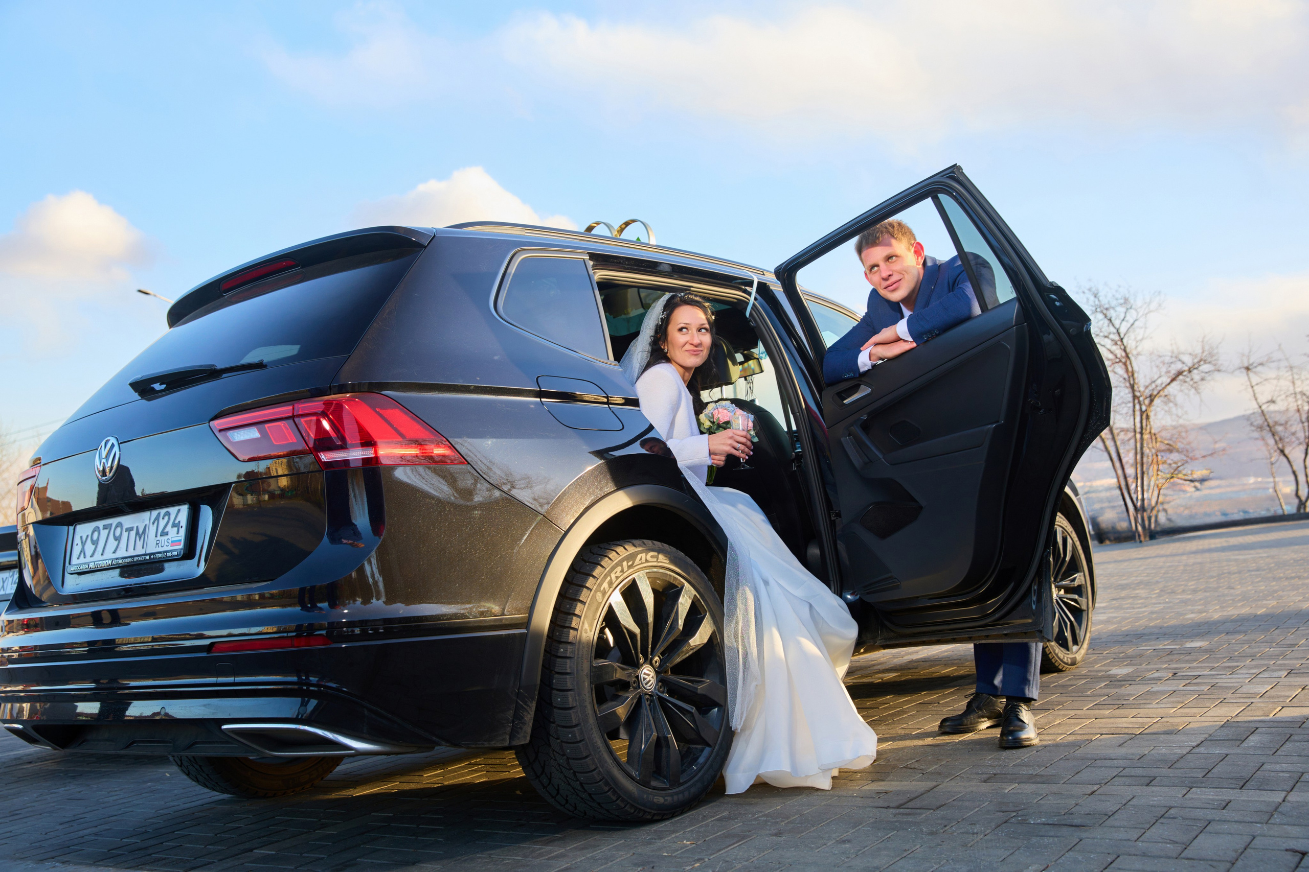 жених смотрит на невесту через окно автомобиля