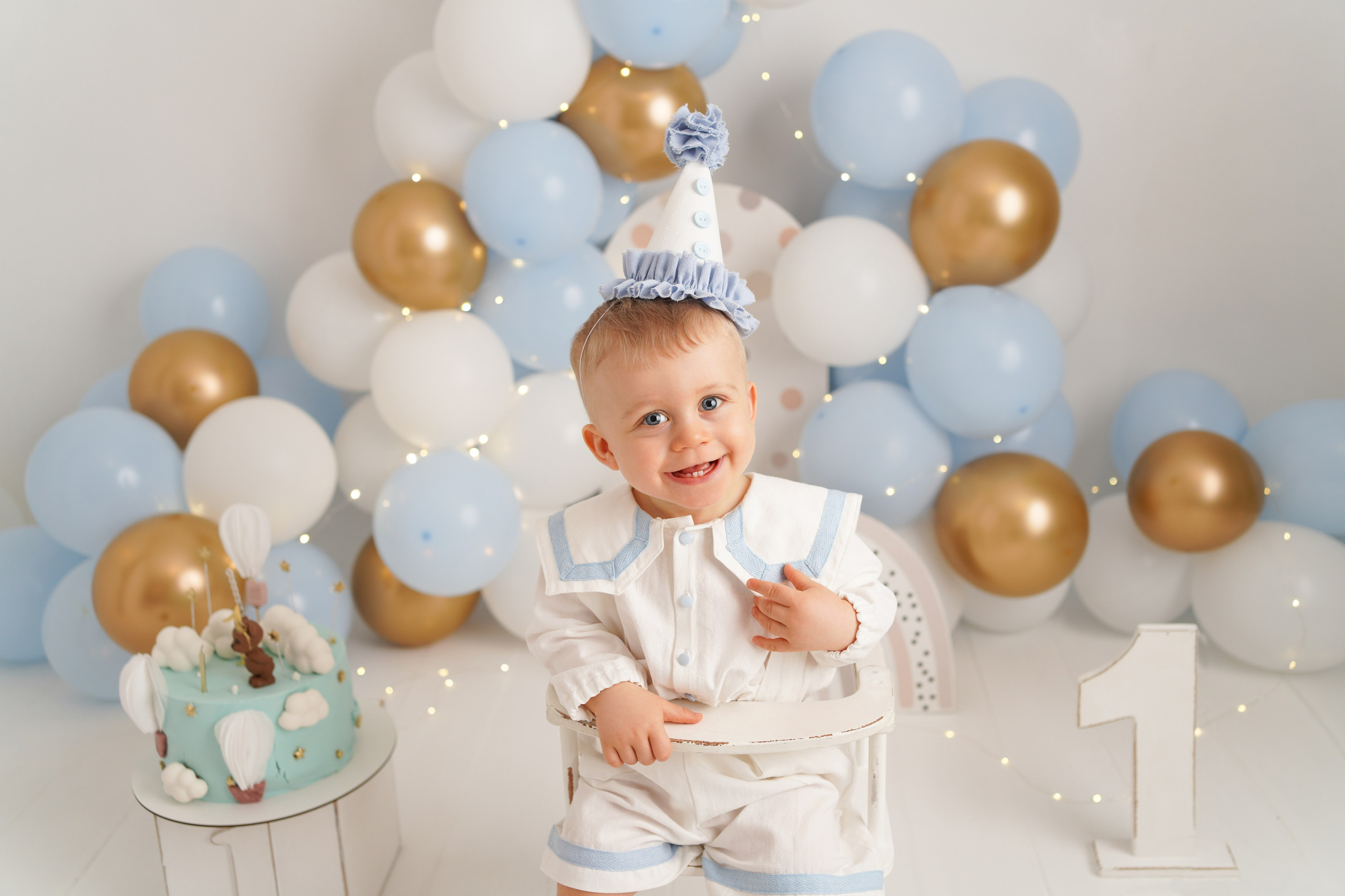Портрет  малыша на день рождения. Он сидит на стульчике. рядом тортик, воздушные шарики.