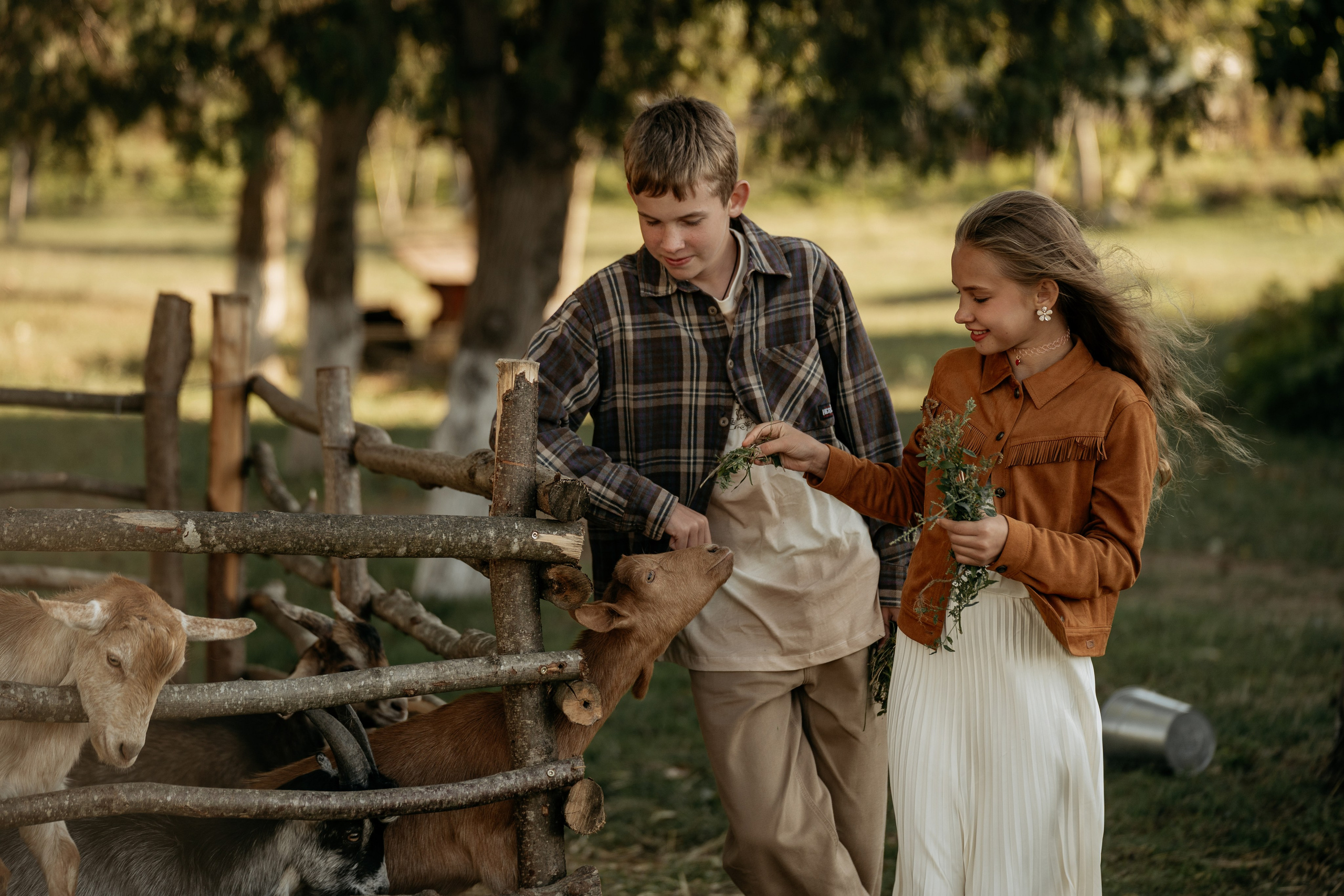 Эмоциональная фотосессия семьи в Анапе: дочка кормит козленка на территории эко-туристического комплекса.