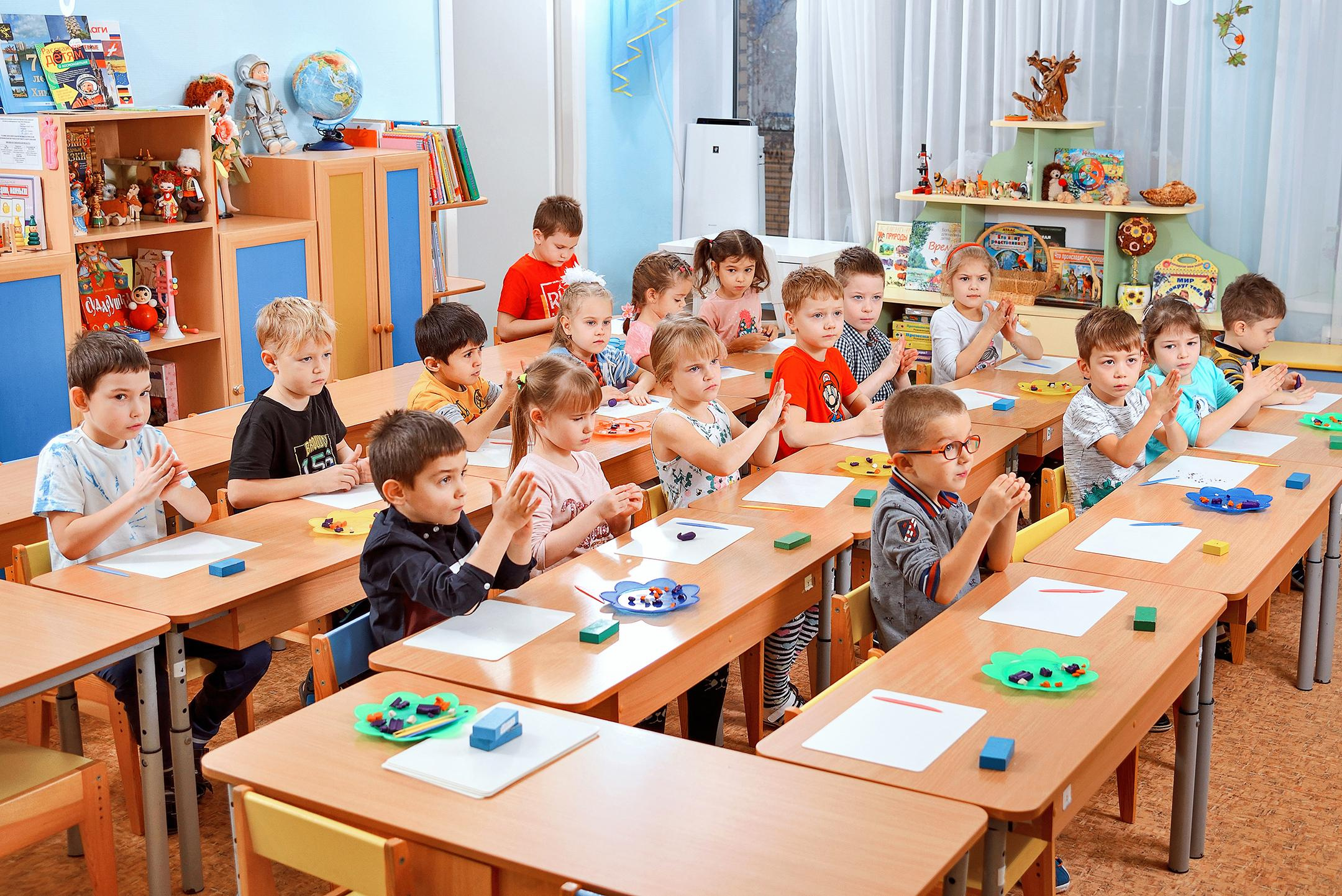 Дети за партами на занятии в детском саду