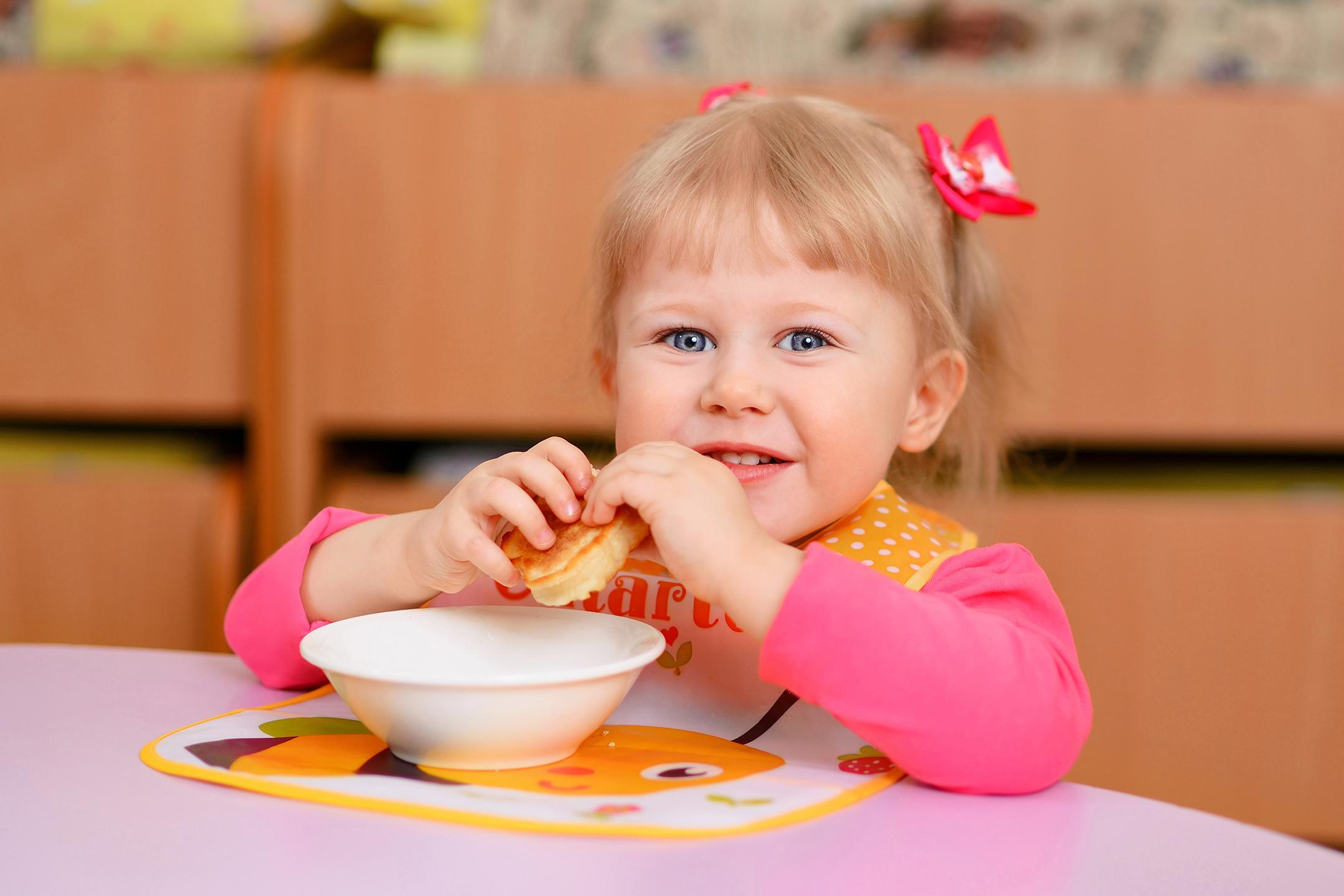 Девочка во время обеда в детском саду
