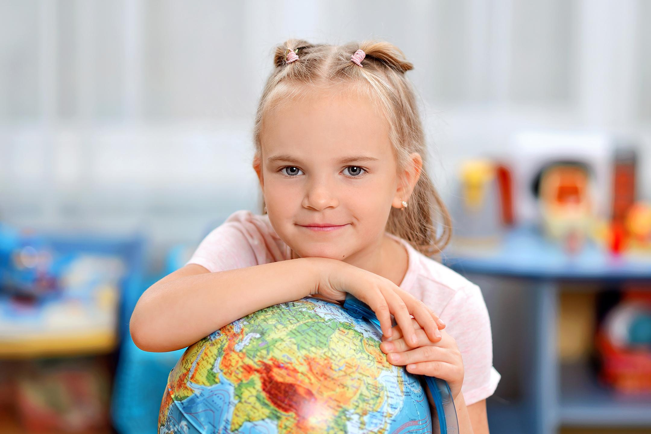 Портрет девочки в детском саду с глобусом для выпускного фото альбома