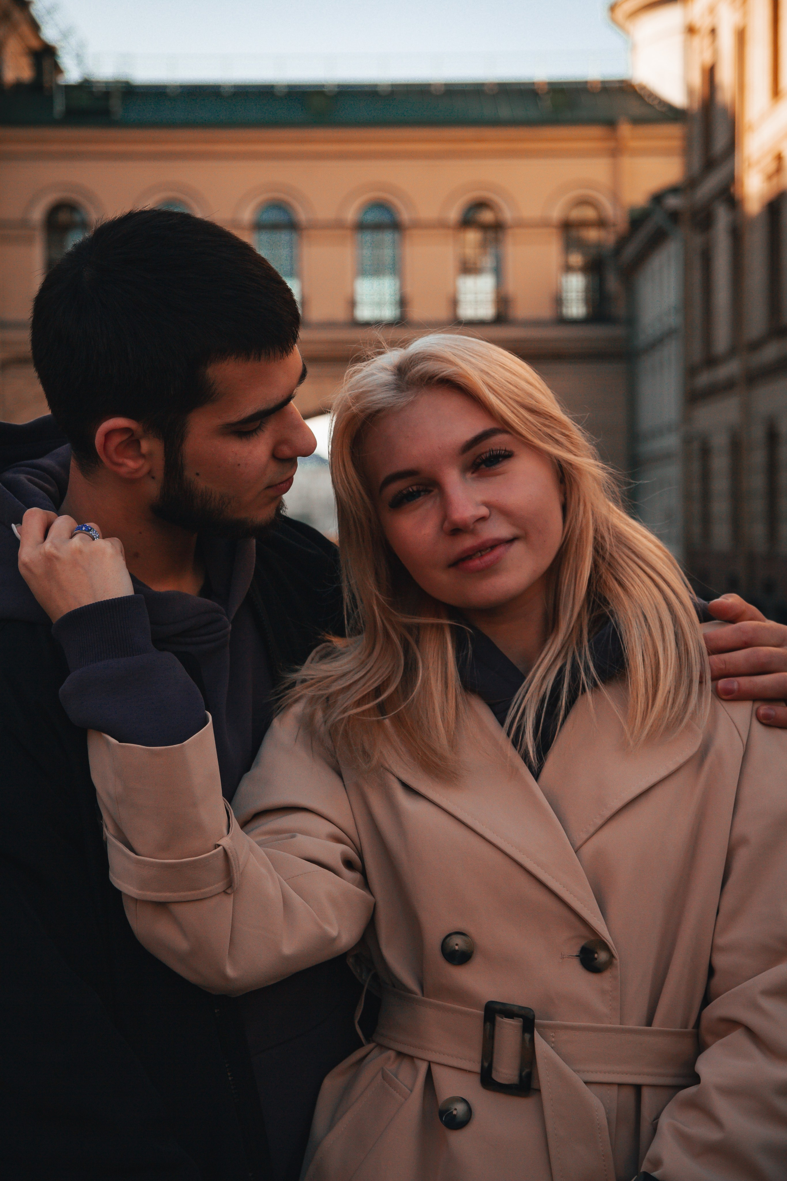 Красивая пара в плаще гуляют по городу