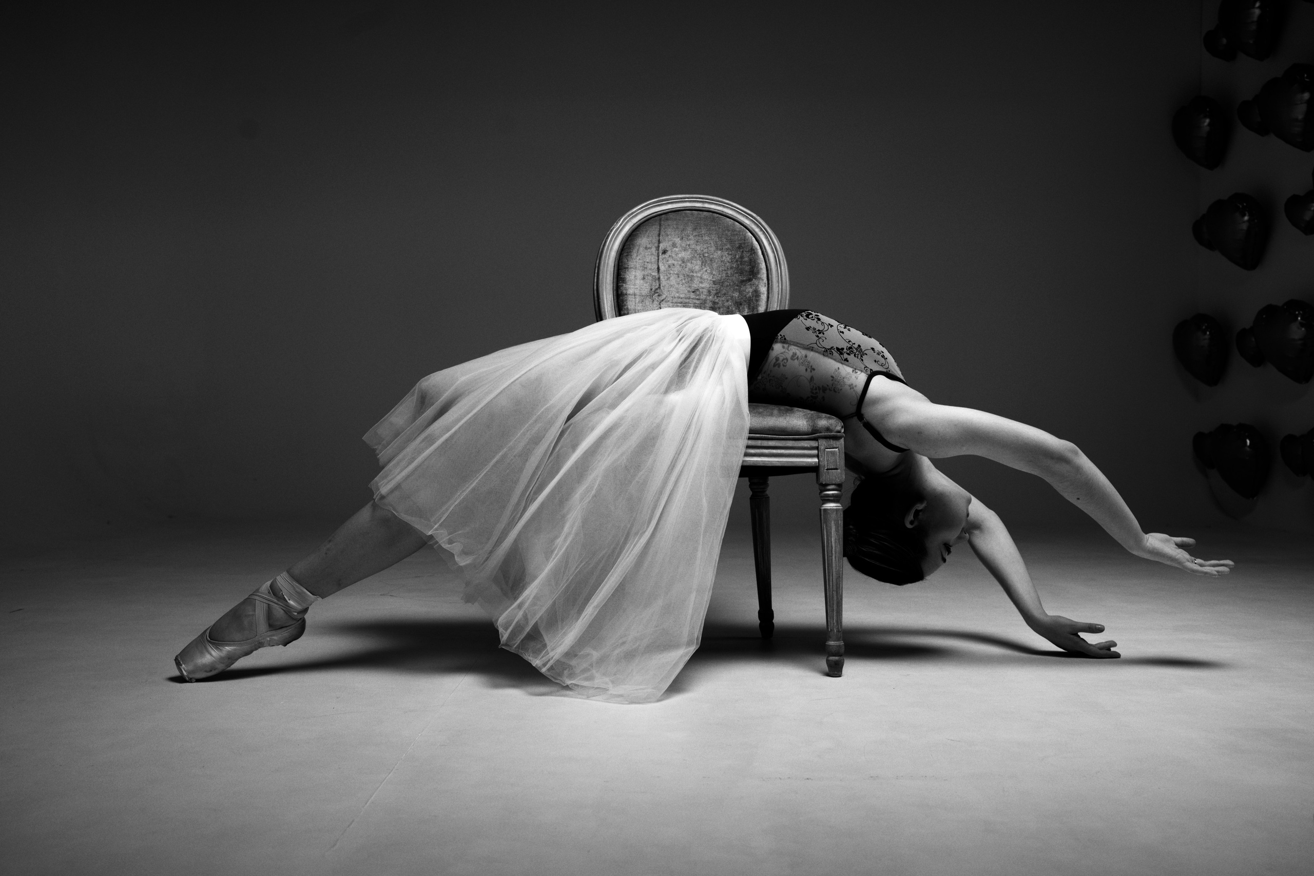 Спортивный фотограф в Тюмени: художественная балетная съемка. Драматичный черно-белый кадр с балериной на стуле, эстетика линий и грация в стиле спорт-арт.