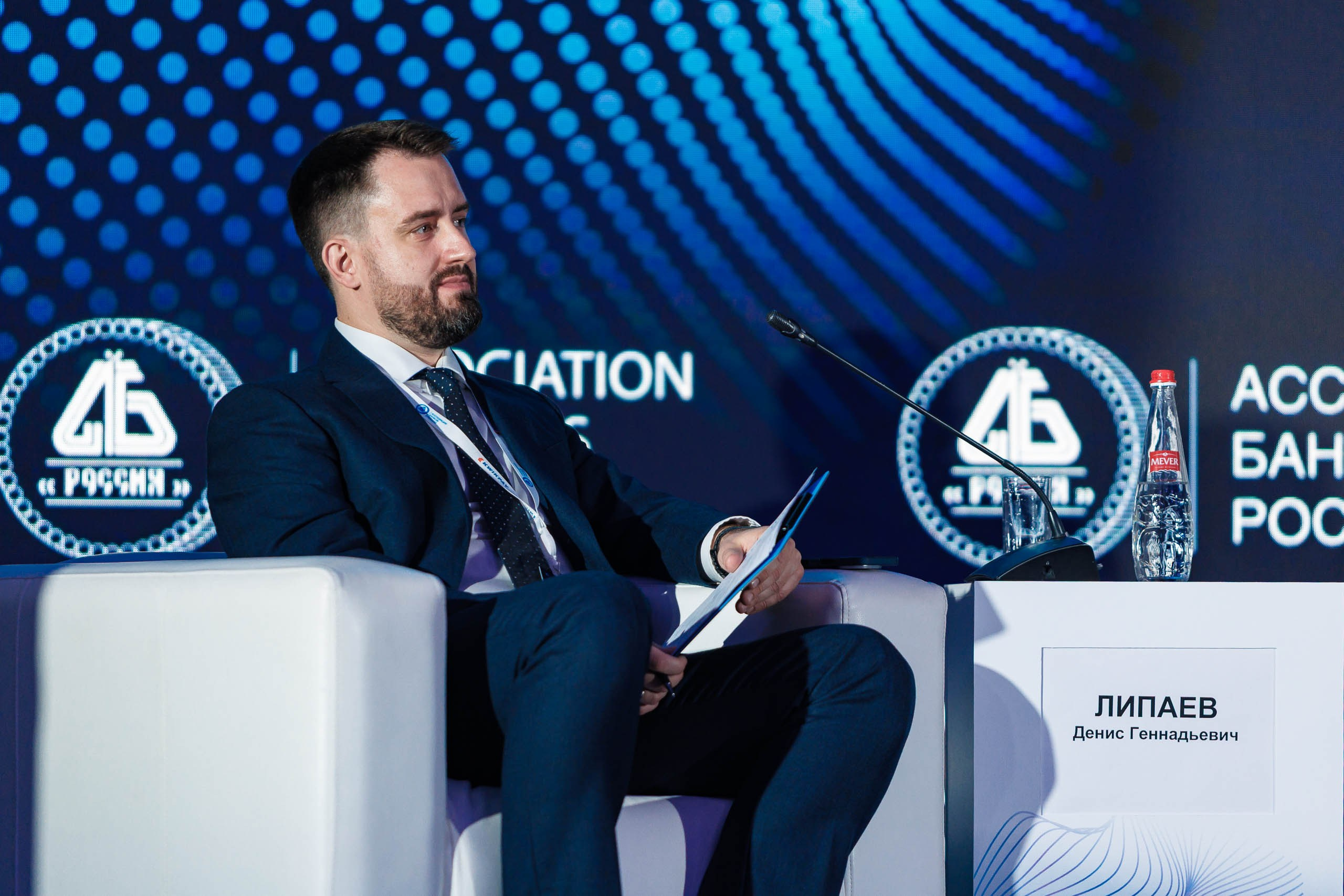 Выступающий спикер форума, микрофон, деловая презентация перед большой аудиторией