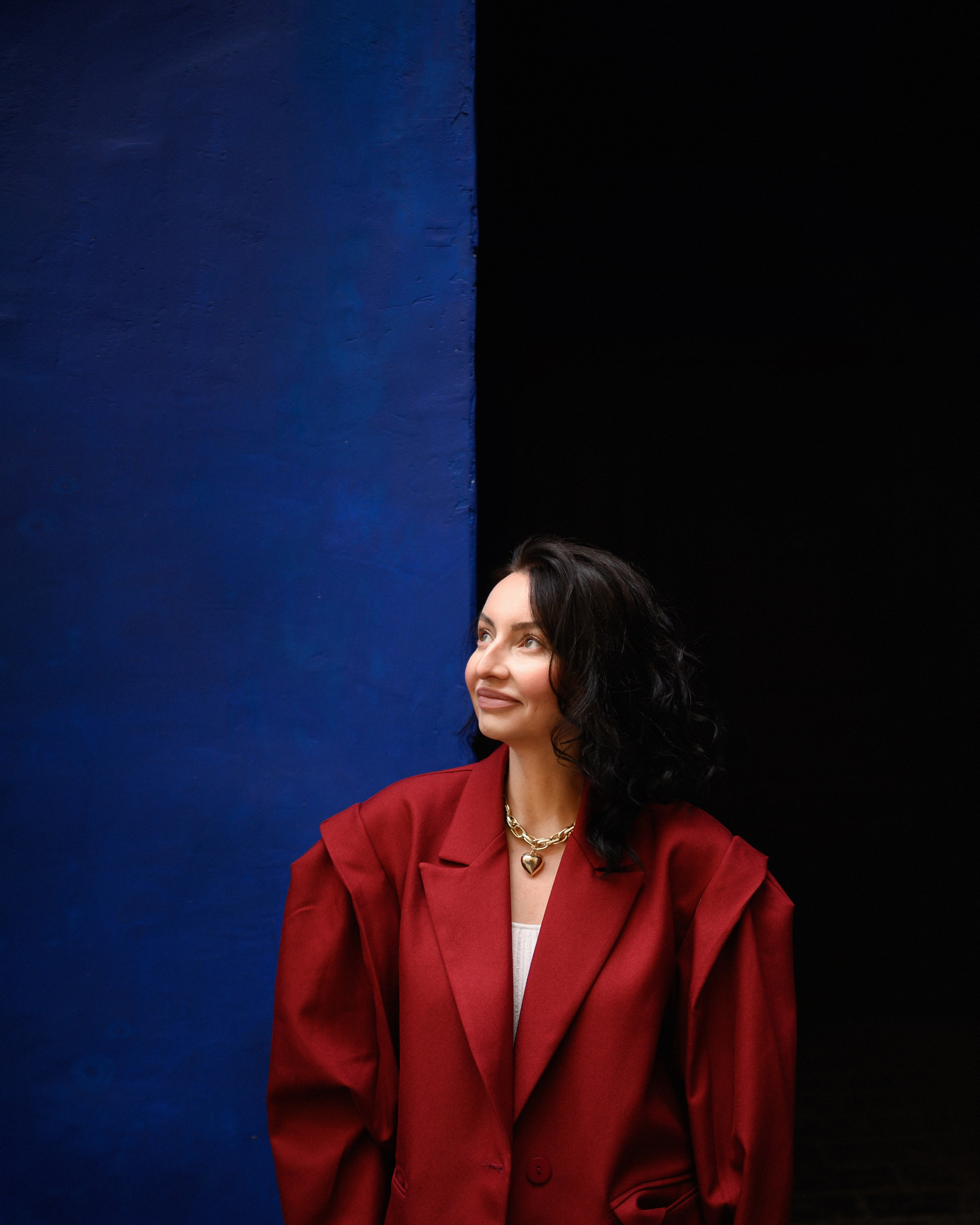 портрет девушки в красном пиджаке на фоне синей стены в Санкт-Петербурге