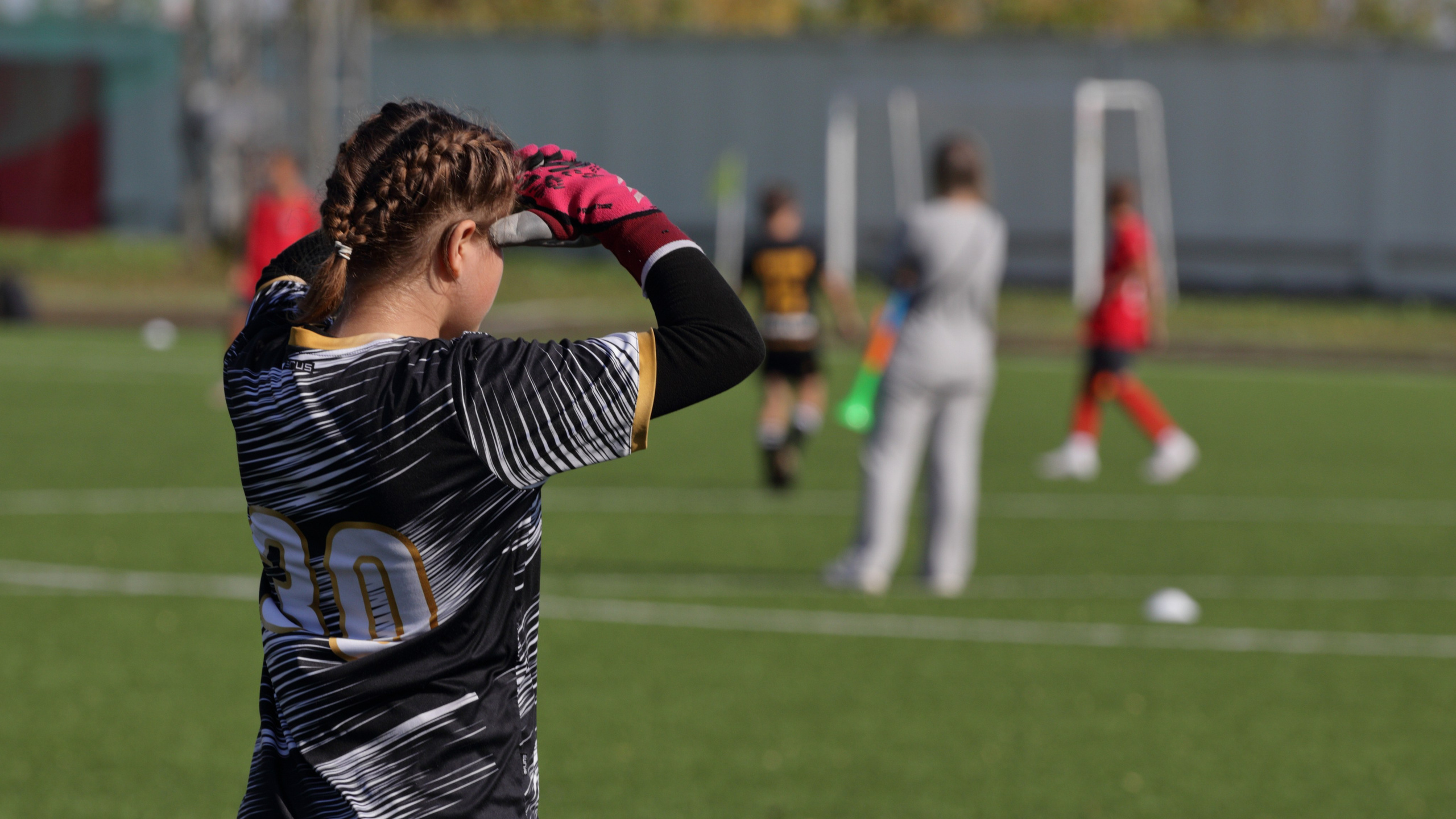 Вратарь смотрит на поле прикрываясь от солнца