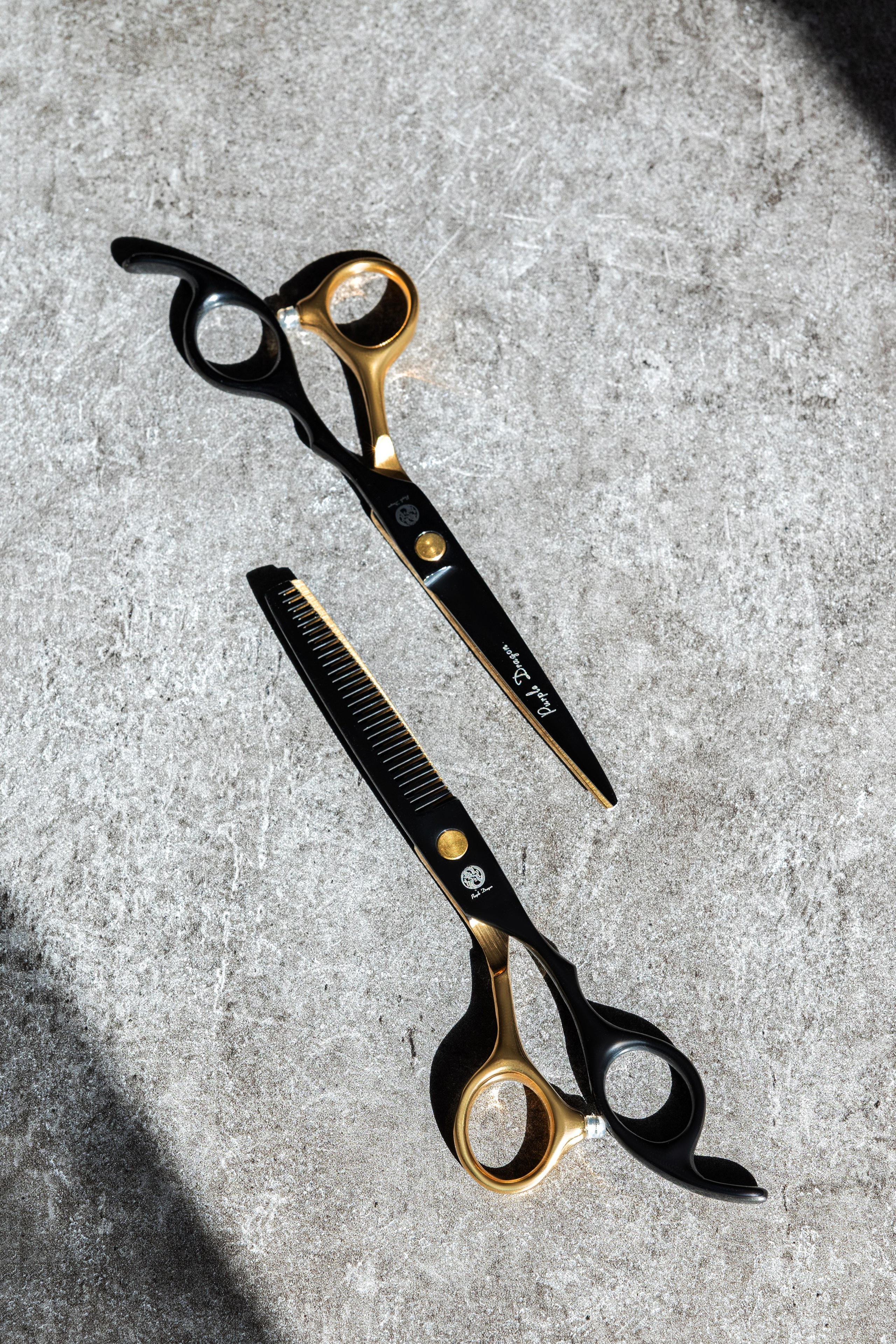 набор парикмахерский , ножницы, рекламное фото на сером бетонном фоне