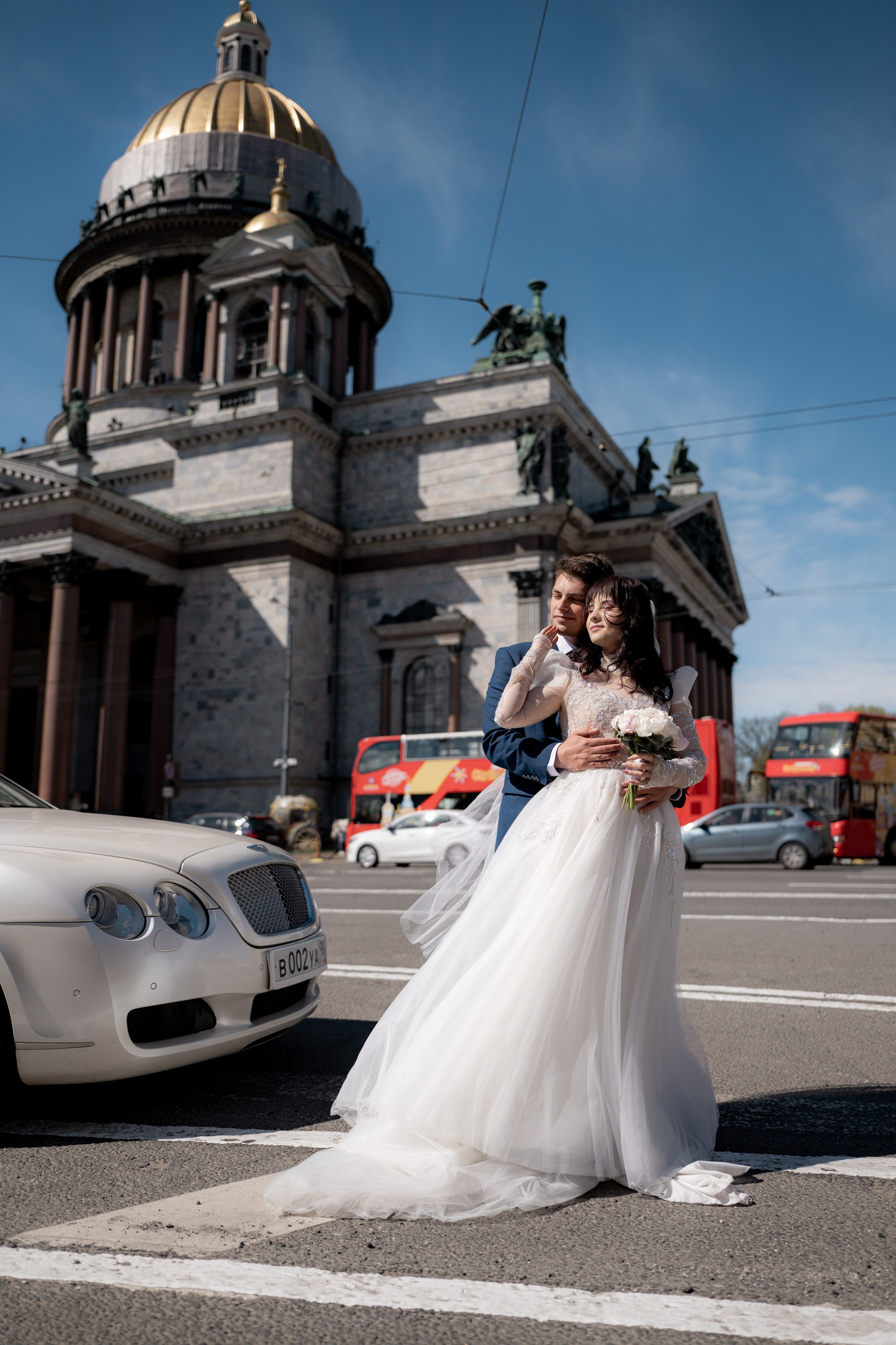 Свадебная фотосессия у Исаакиевского собора. Жених обнимает невесту на фоне собора.