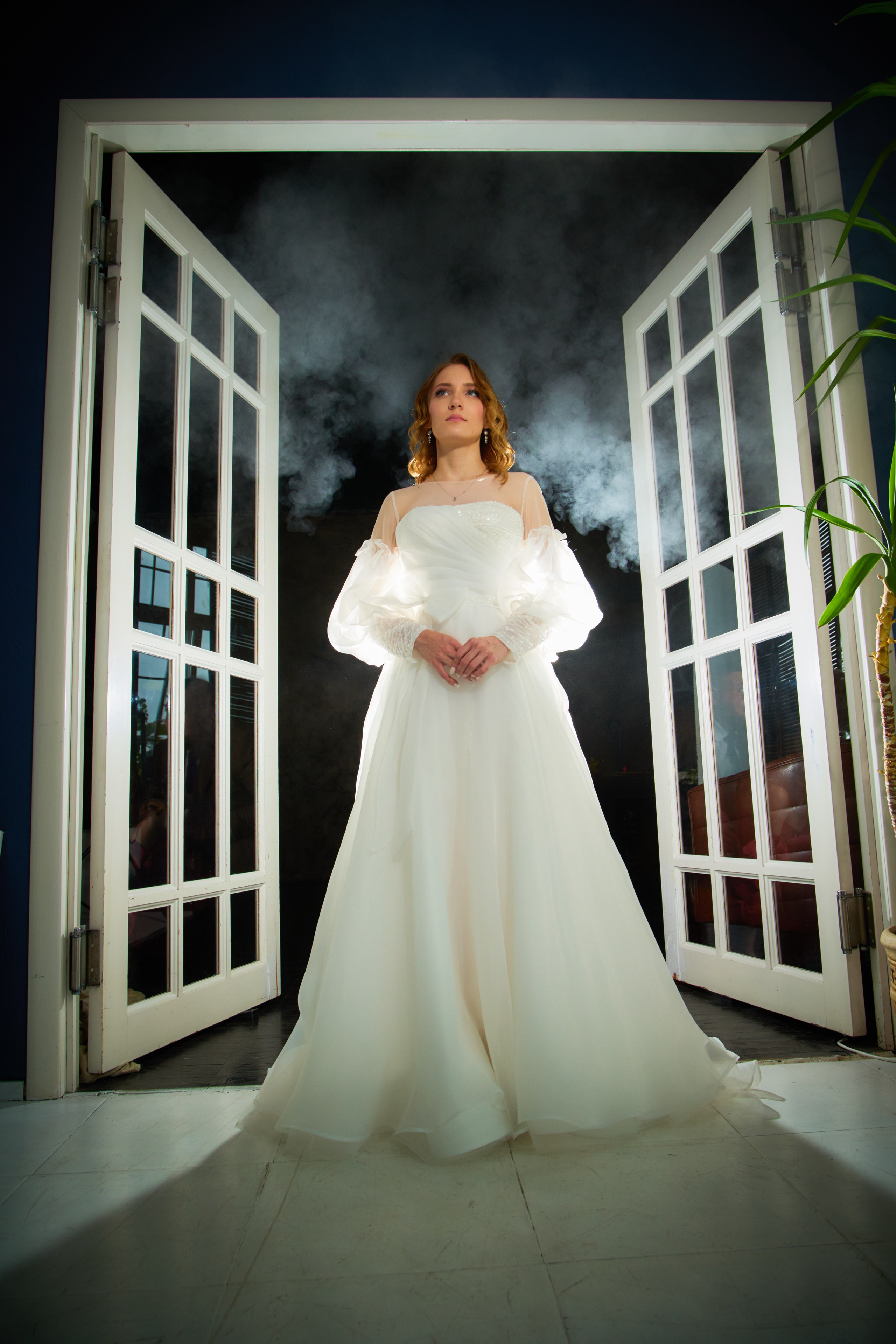 невеста выходит из красивой двери в фотостудии а сзади дым