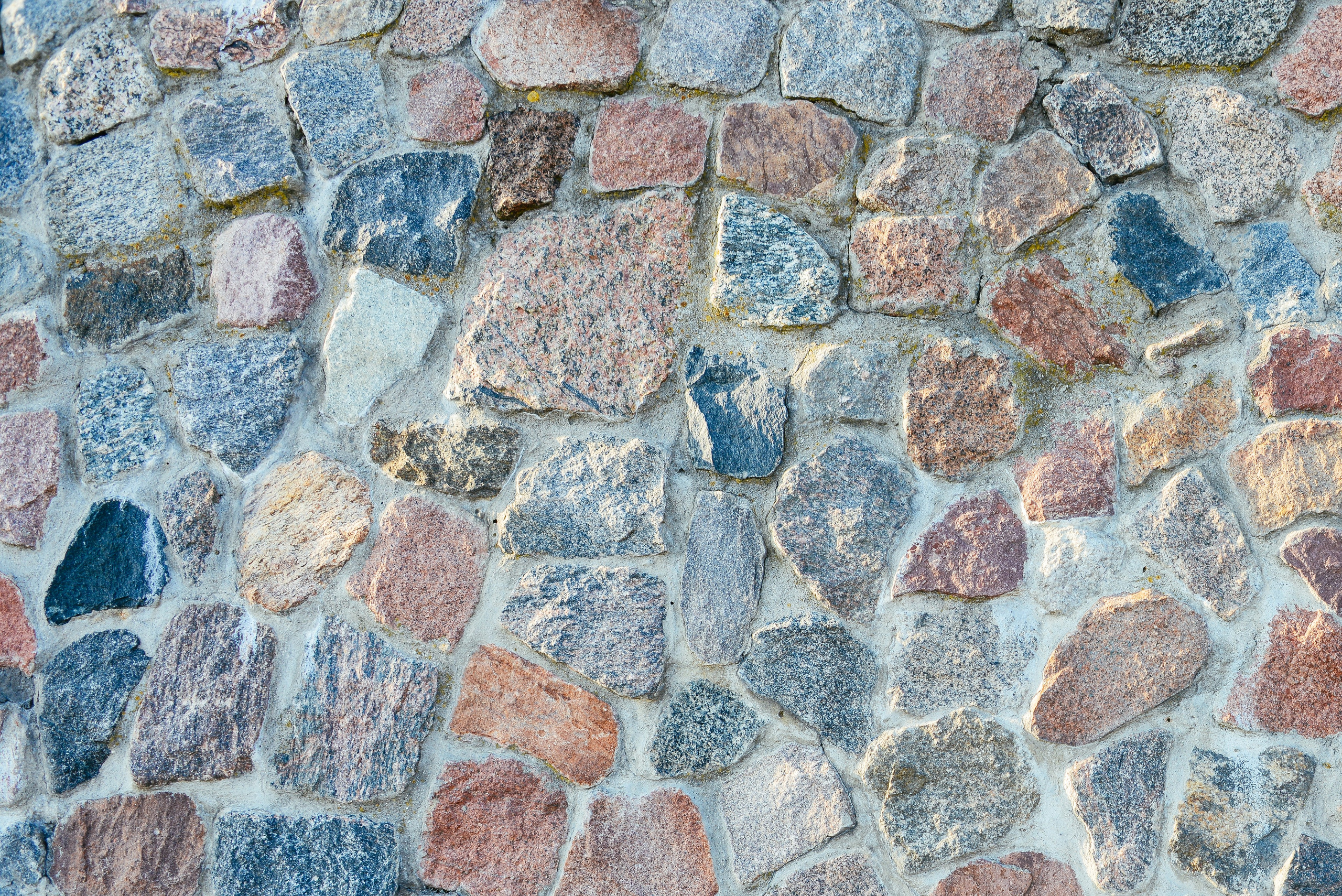 Каменная стена из разноцветных камней, текстура, паттерн, фон